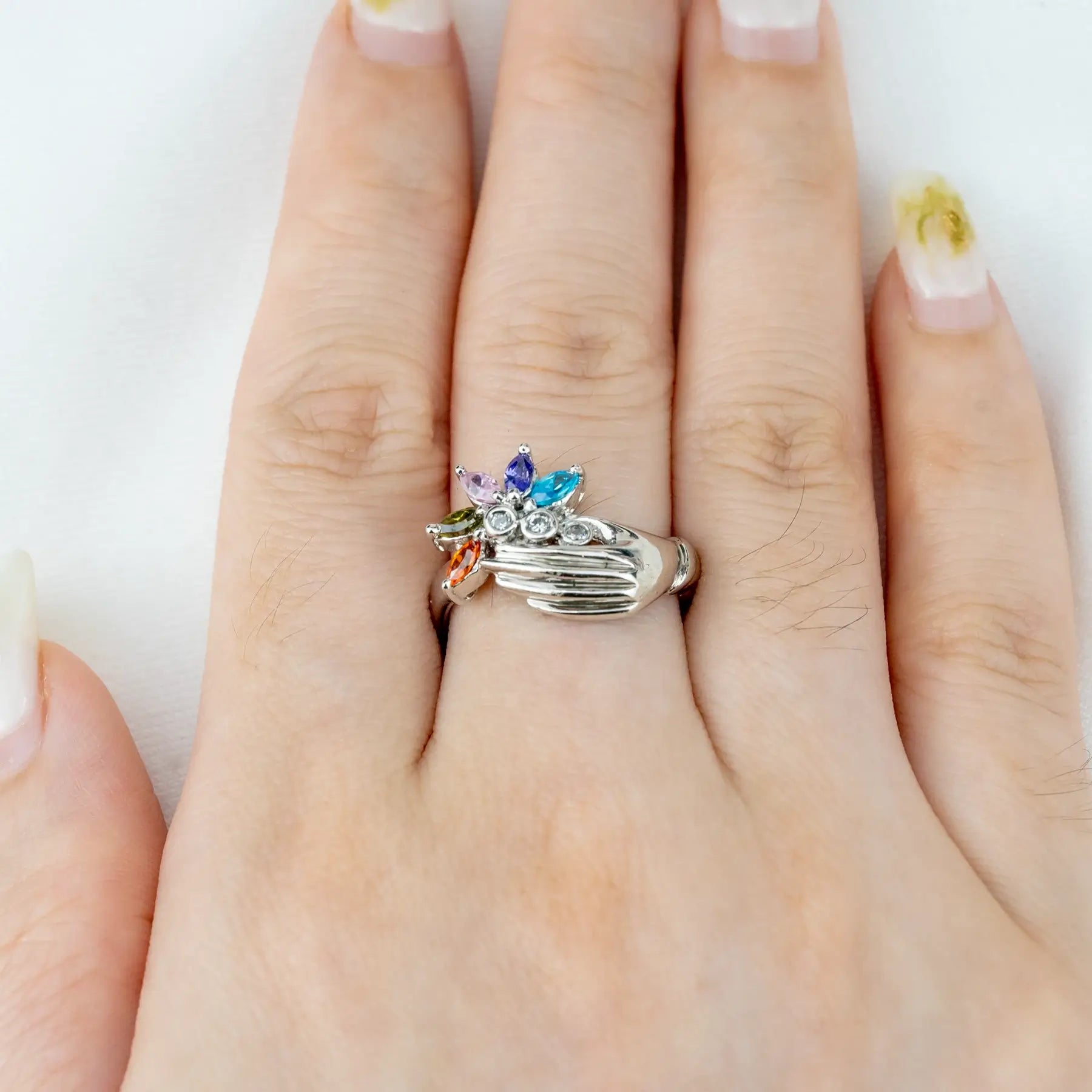 White Gold Hand Holding Colorful Gemstone Flower Ring – Artistic Statement