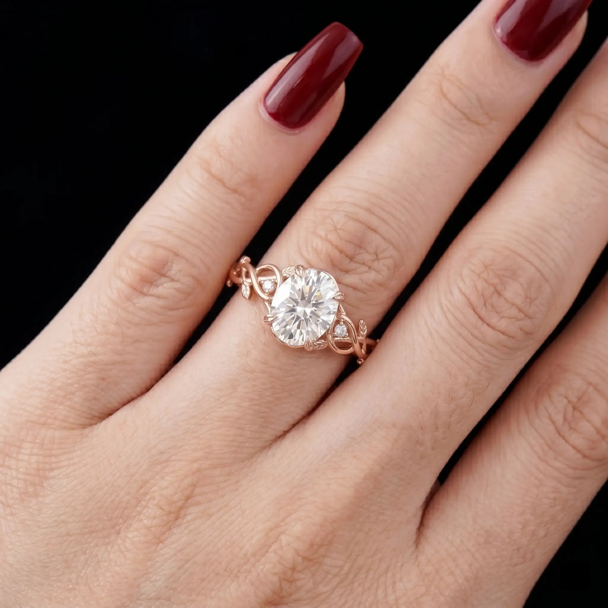 Luminous handmade oval moissanite ring on hand showing intricate hand-sculpted leaf branch and vines