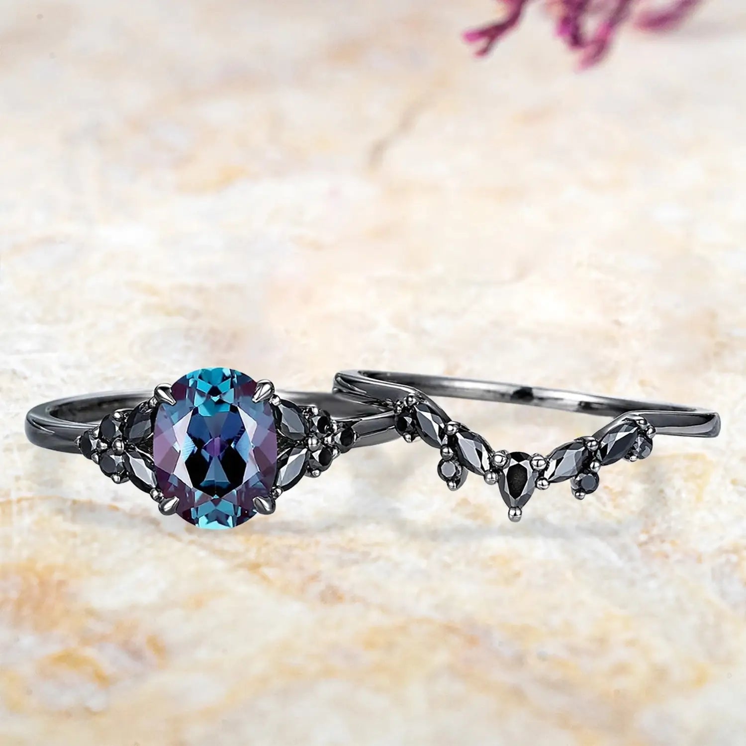 Oval alexandrite cluster engagement ring and black onyx chevron wedding band displayed separately showing Gothic June birthstone bridal set