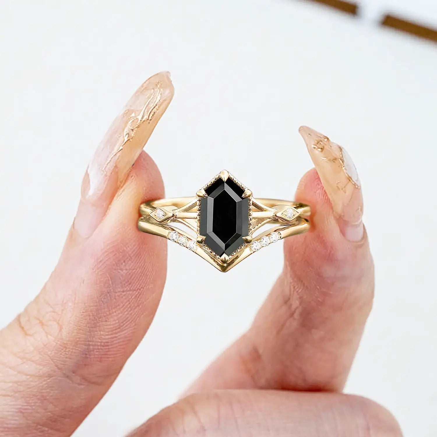 Woman wearing hexagonal black onyx engagement ring set yellow gold Art Deco style
