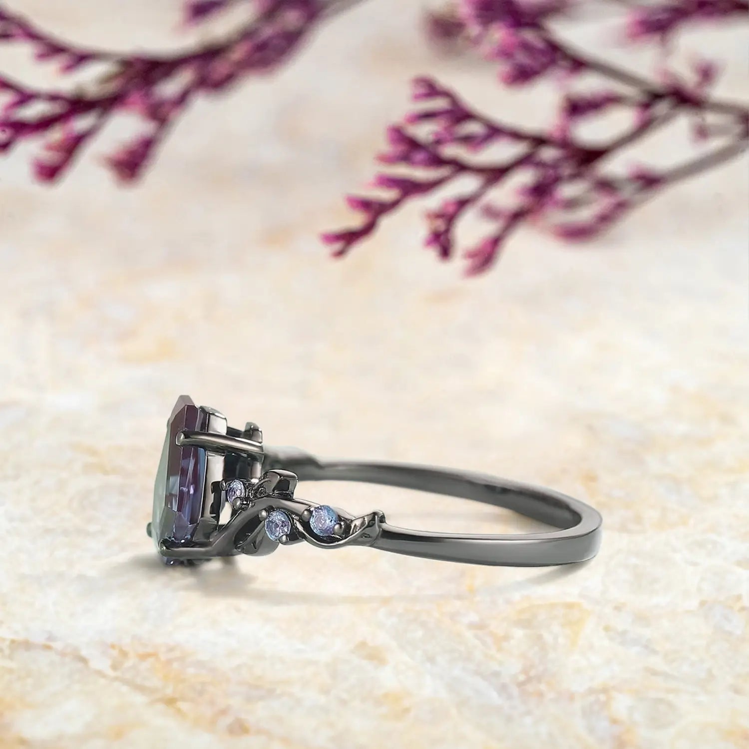 Close up detail of coffin cut alexandrite center stone with round alexandrite accents in leaf setting