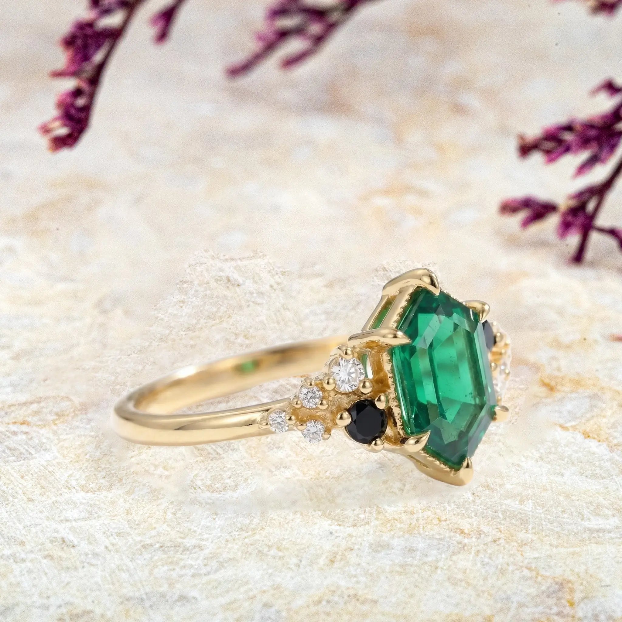 Side view of long hexagon emerald ring showing modern cluster setting