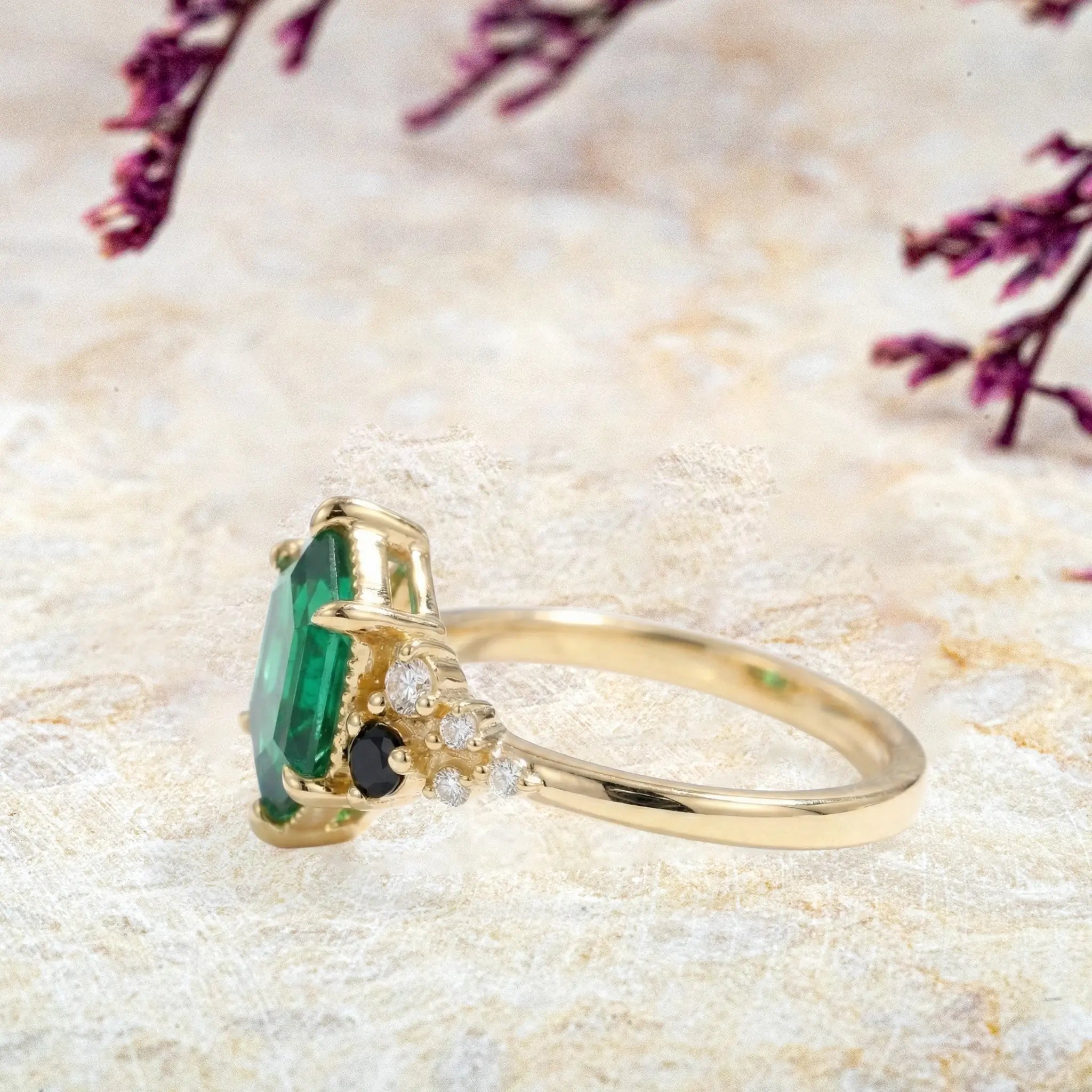 Side profile of emerald engagement ring with black onyx accents