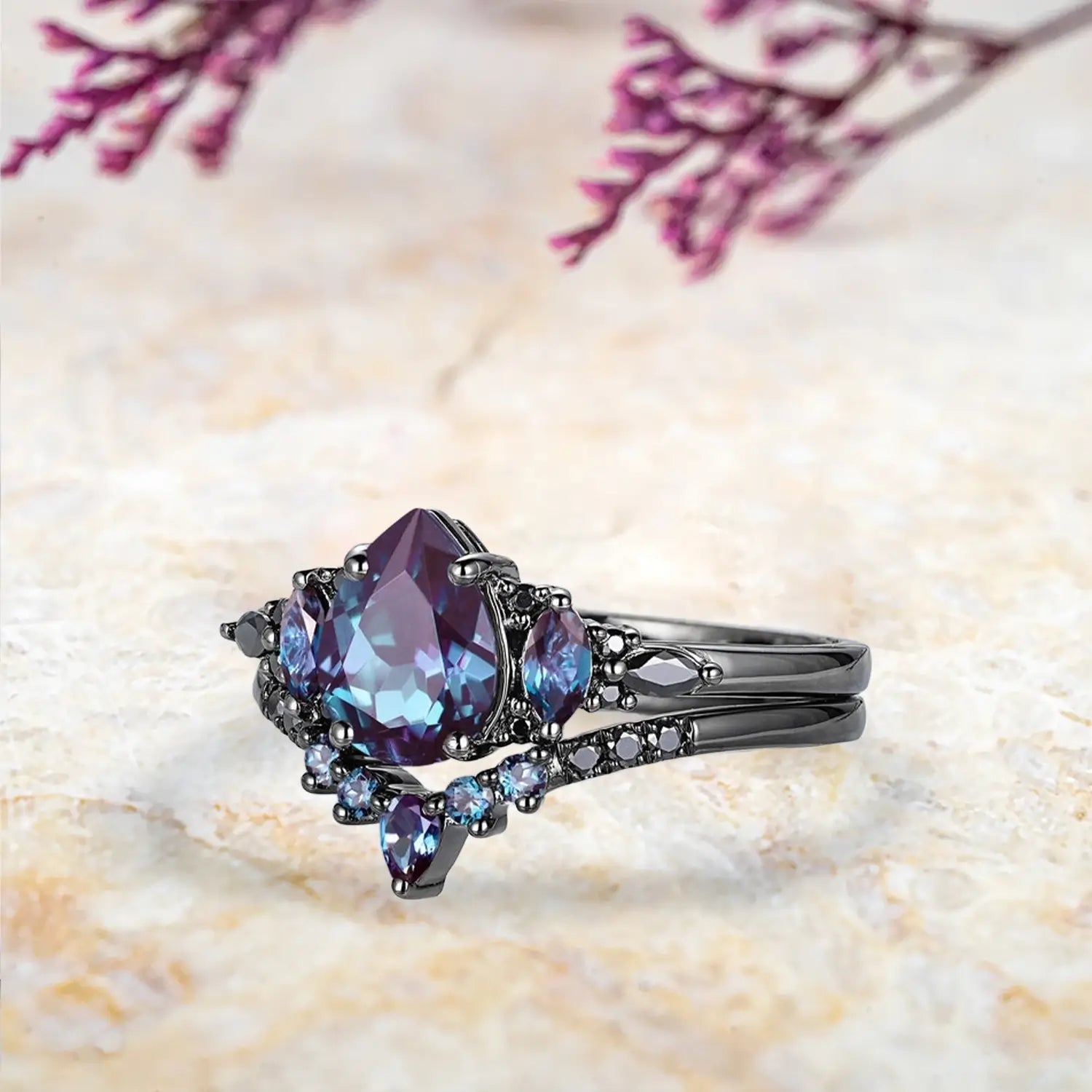 Side view of pear alexandrite ring showing black moissanite cluster design and curved chevron wedding band profile