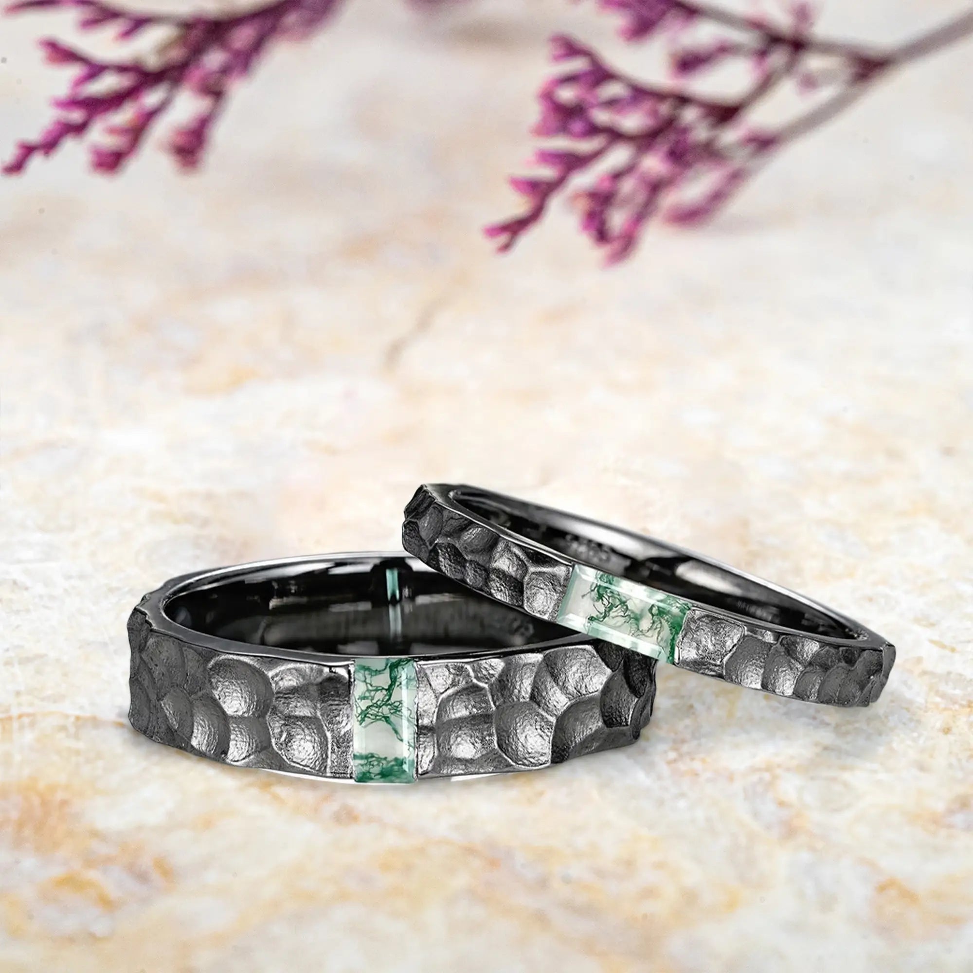 Side view of moss agate couple rings showing hammered texture and black gold band profiles