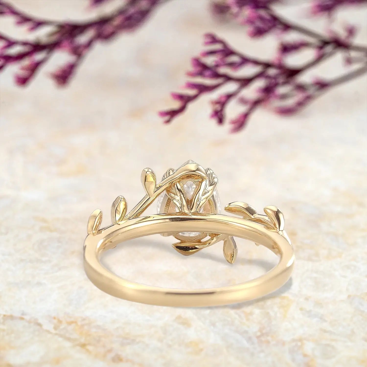 Back view of moissanite engagement ring showing yellow gold band and leaf setting