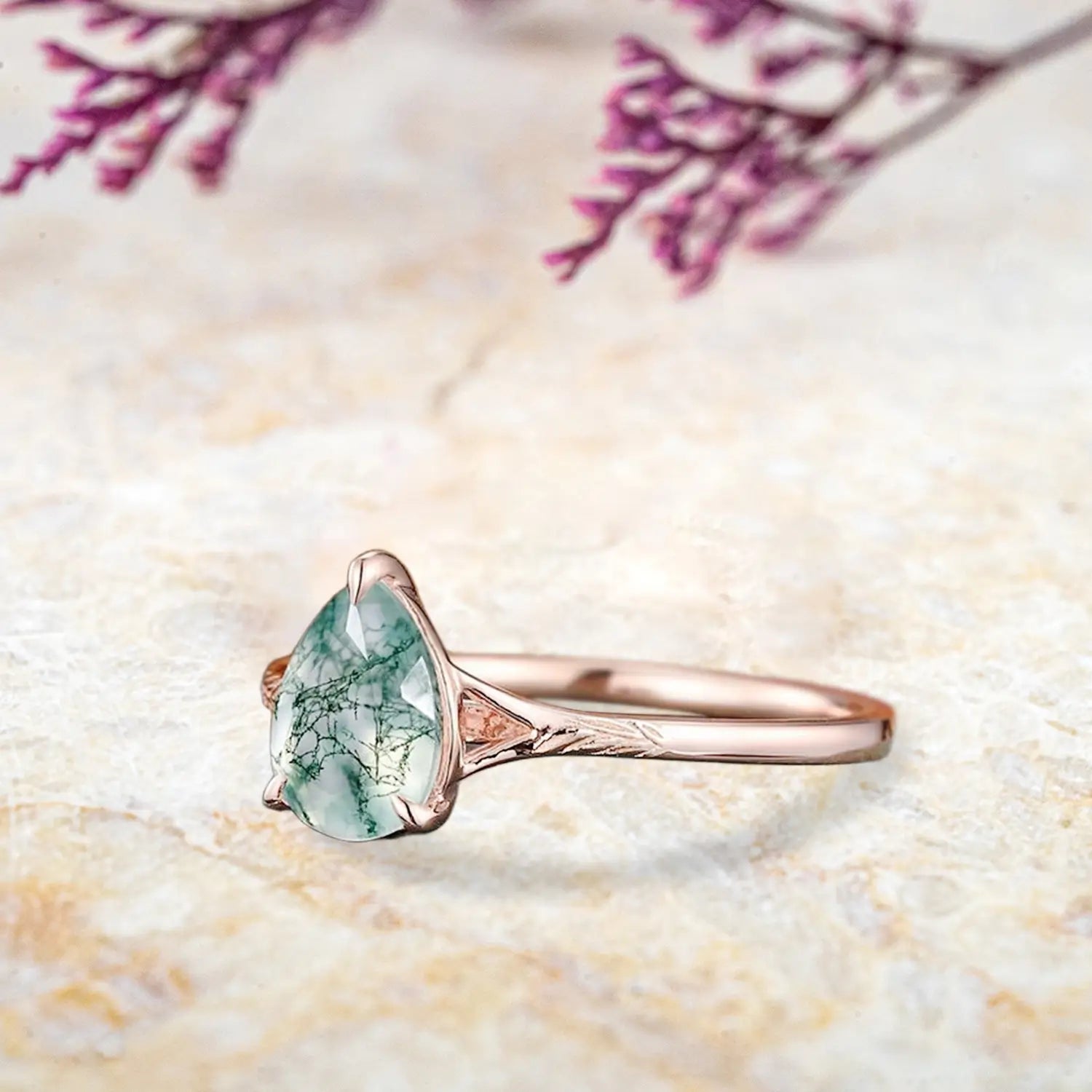 Side view of pear moss agate ring showing rose gold leaf engravings and solitaire setting