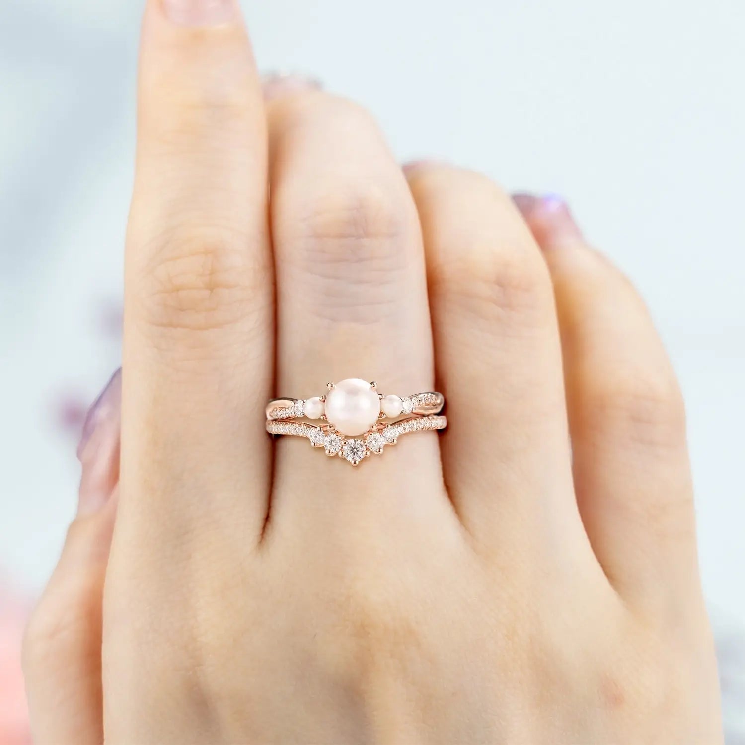 Woman wearing round Akoya pearl engagement ring in rose gold