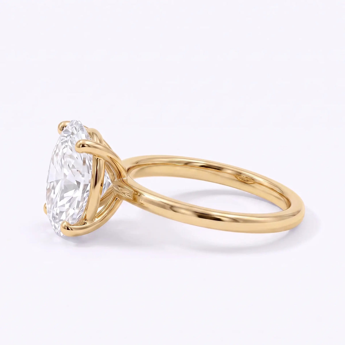 Left view of oval lab diamond solitaire ring with a slim polished gold band