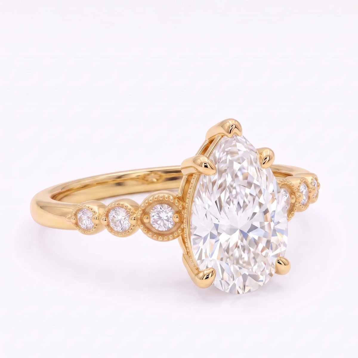 Close-up of pear cut moissanite with six round accent stones and milgrain-inspired frames