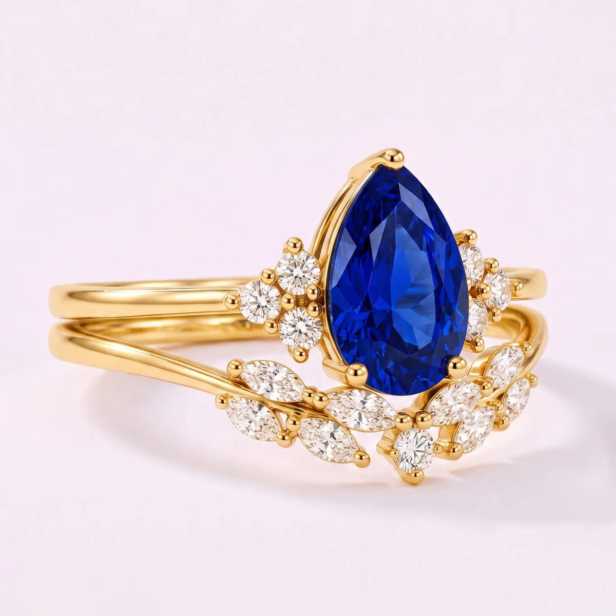 Close-up of pear cut lab sapphire center stone with moissanite cluster accents and marquise band