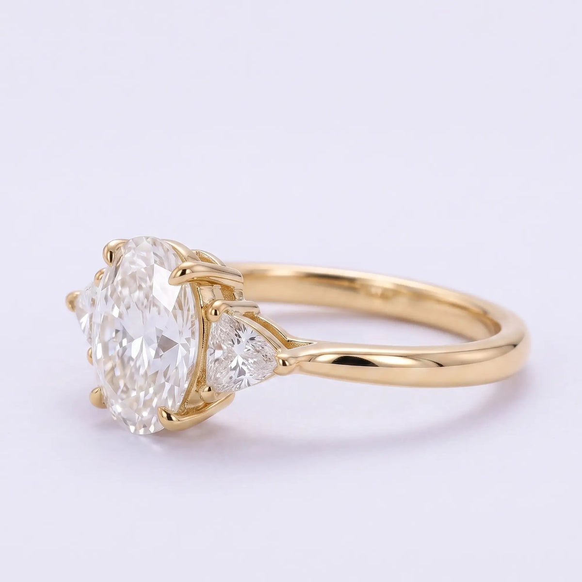 Left view of oval moissanite three stone ring with minimalist polished gold band