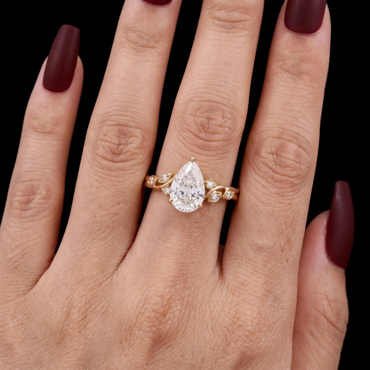 Pear moissanite leaf engagement ring worn on hand