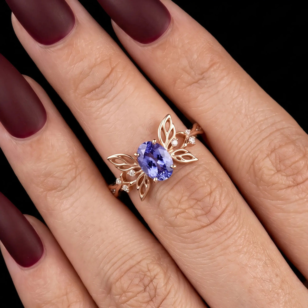 Oval sapphire butterfly engagement ring worn on hand