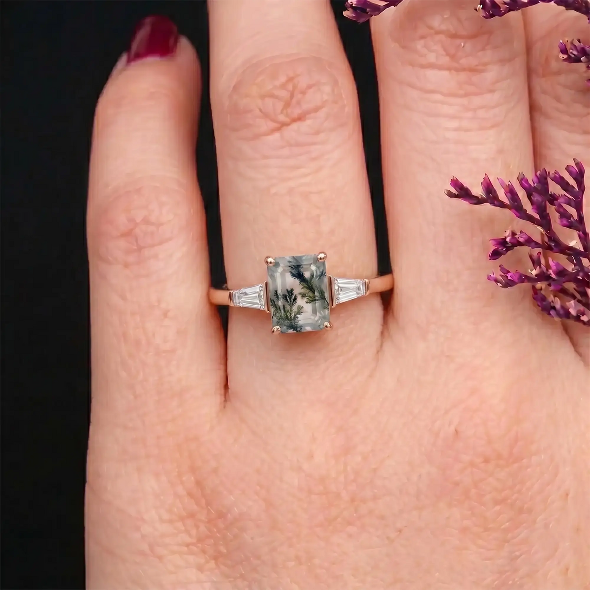Elegant alternative bridal emerald-cut moss agate three-stone ring shown worn on a woman's finger, highlighting its clean profile