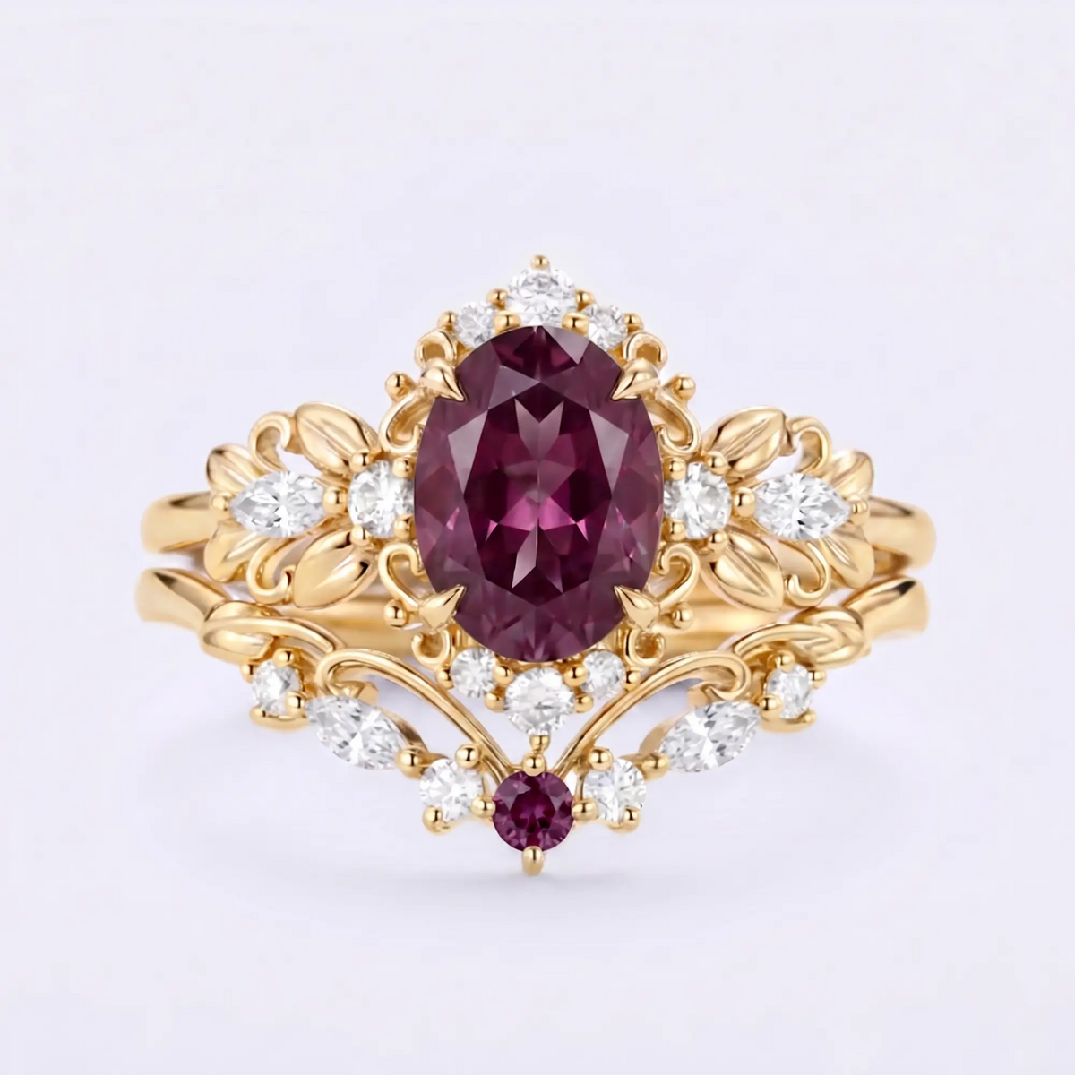 Handcrafted vintage-inspired oval lab-grown alexandrite engagement ring stacked with a sculpted leafy marquise moissanite wedding band in solid yellow gold by Orleone