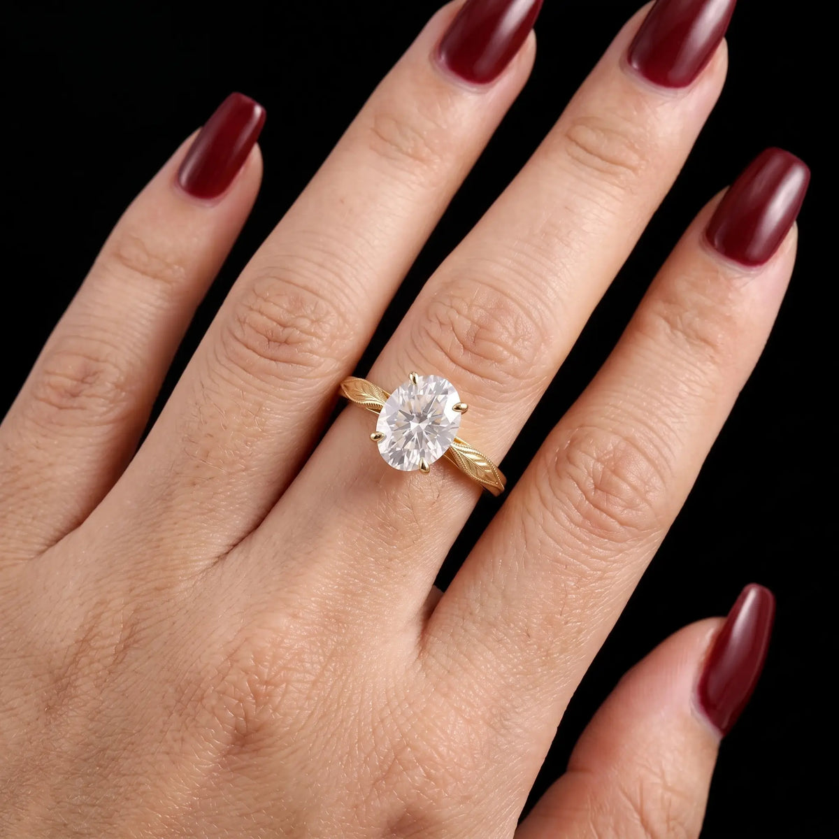 Anillo de compromiso solitario con diamante de laboratorio ovalado y detalles de hoja, lucido en la mano.