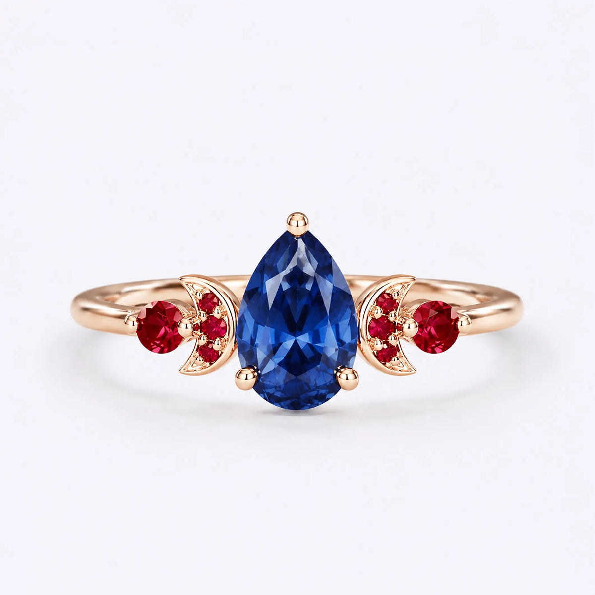 Pear cut sapphire engagement ring with ruby crescent moon accents in rose gold