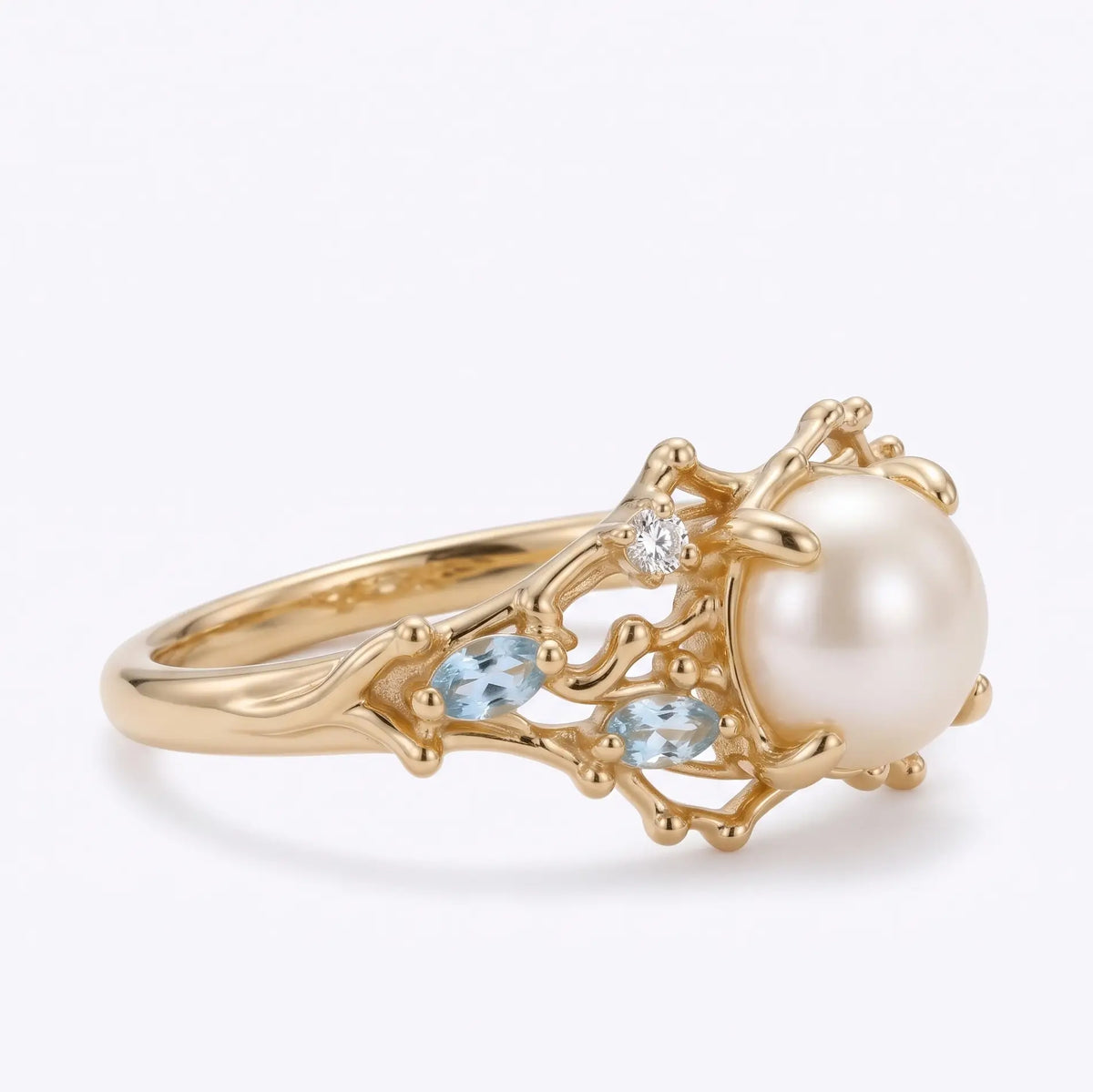 Front view of pearl coral engagement ring with aquamarine accents