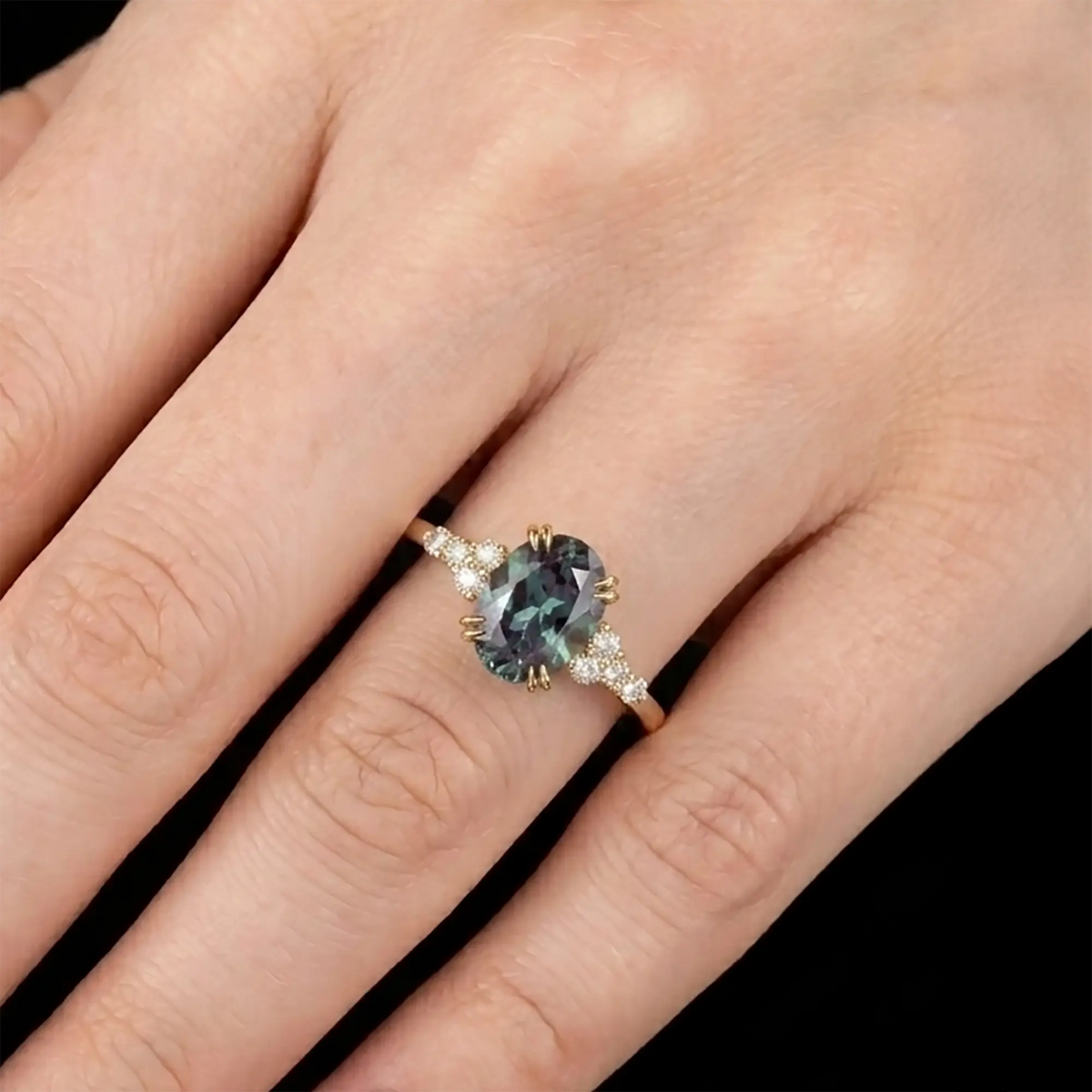 Dainty alternative bridal oval alexandrite cluster anniversary ring shown worn on a woman finger