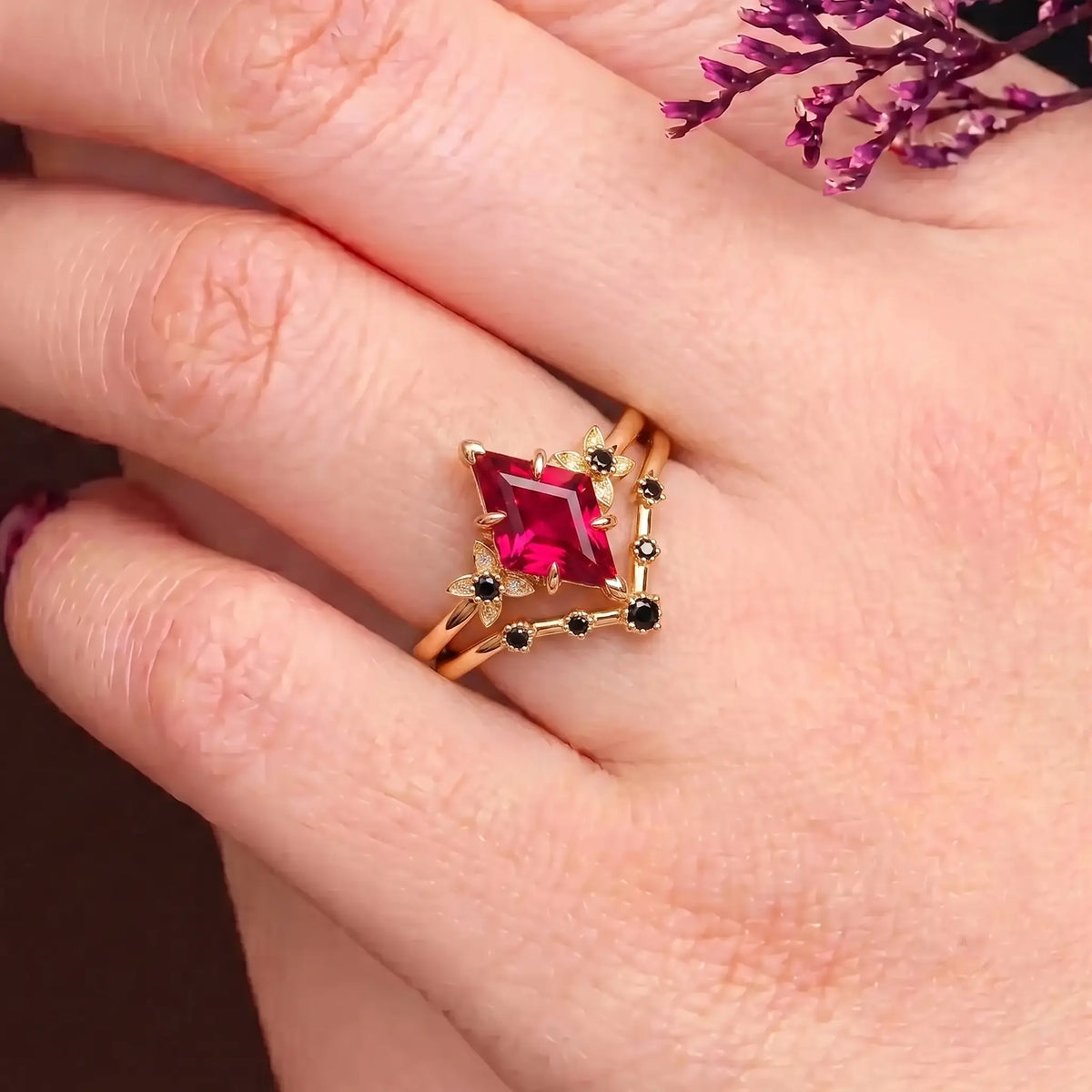 Kite cut ruby floral bridal ring set worn on hand with matching black onyx band