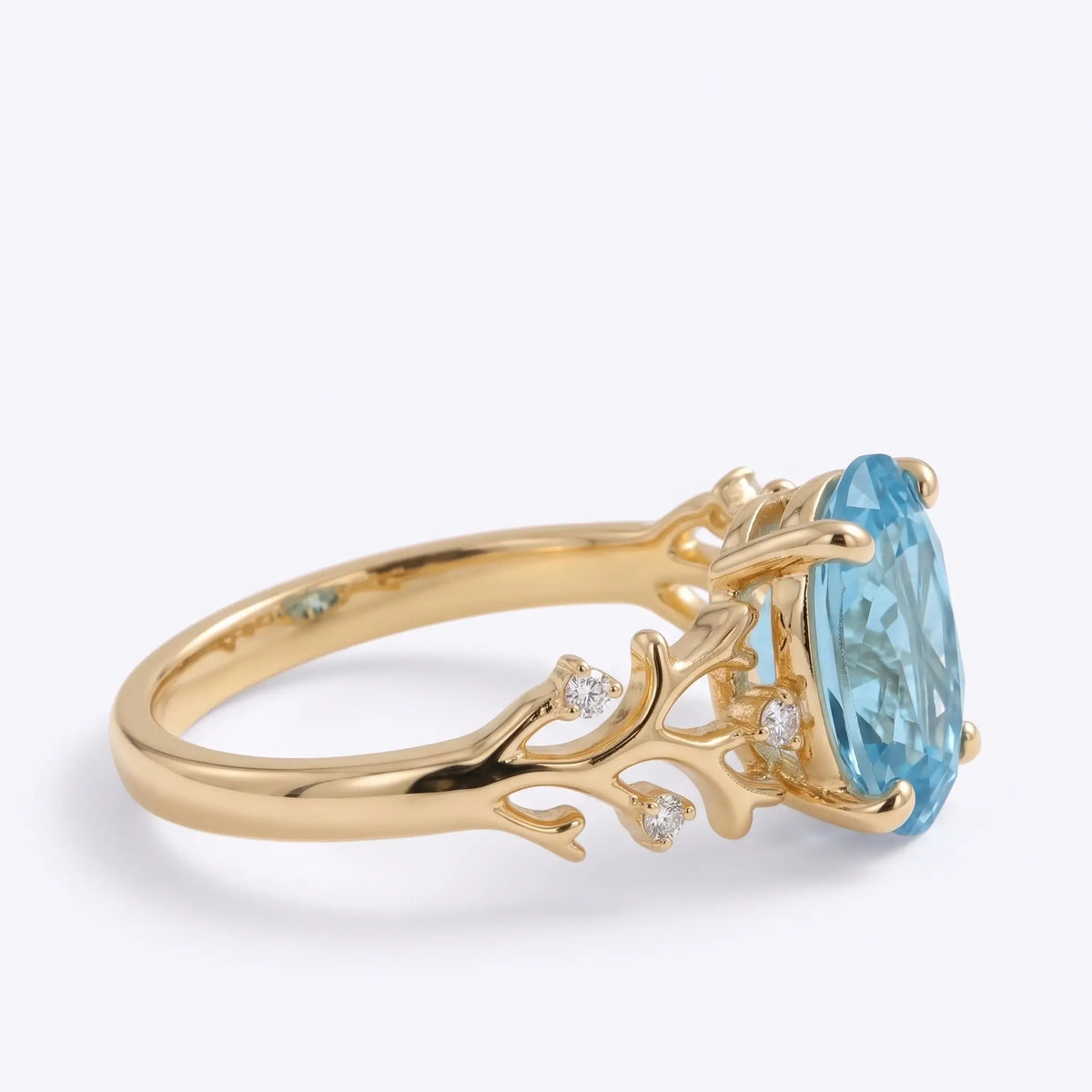 Side profile of coral branch engagement ring with openwork gold shoulders