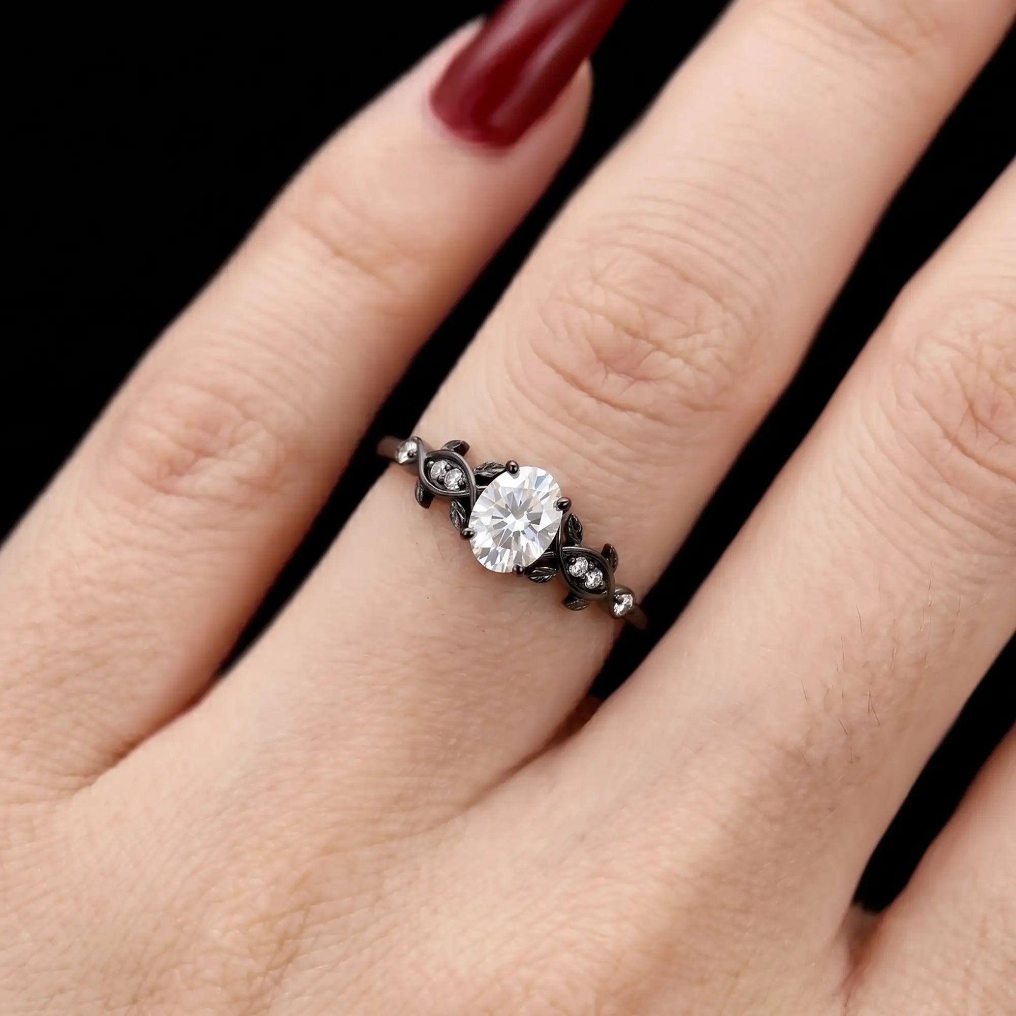 Luminous handmade black gold oval moissanite ring on hand showing intricate twisted tree branch and leaves