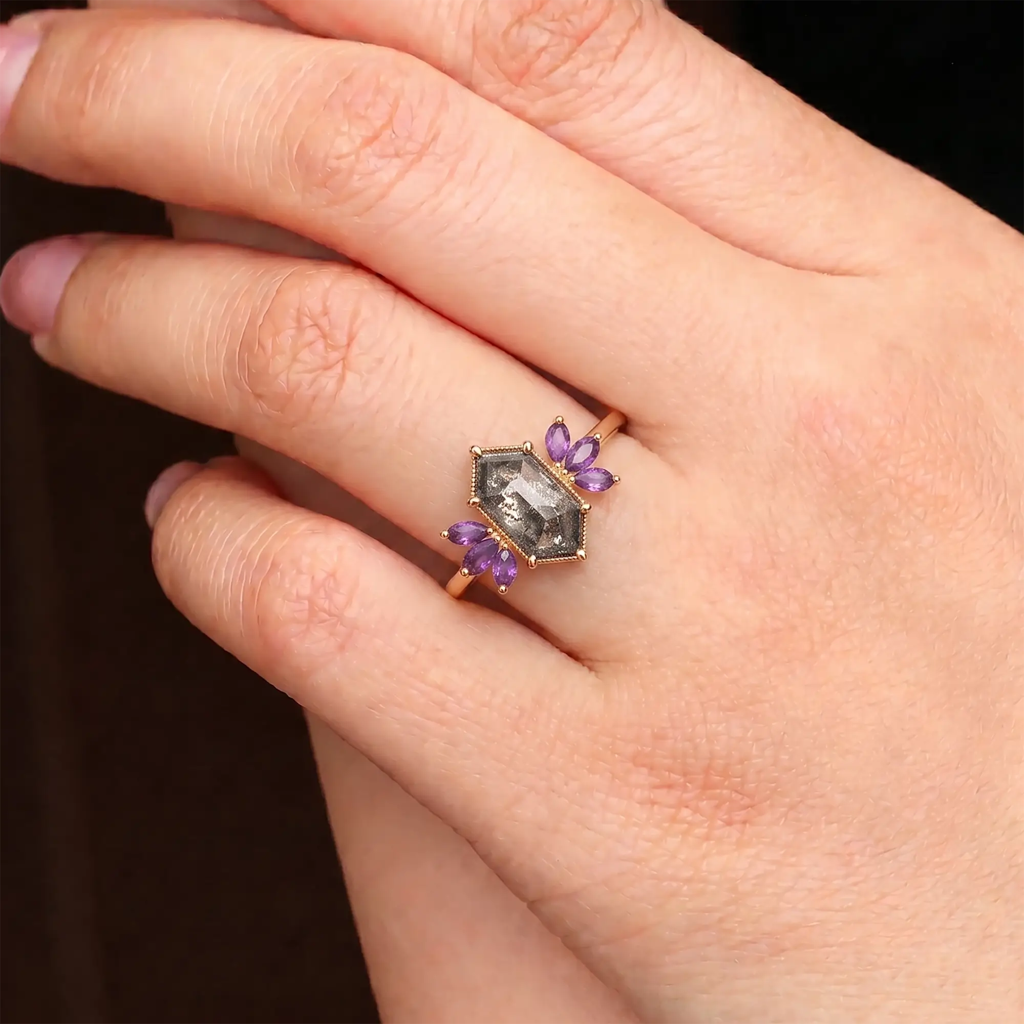 Salt and pepper diamond petal cluster engagement ring worn on hand
