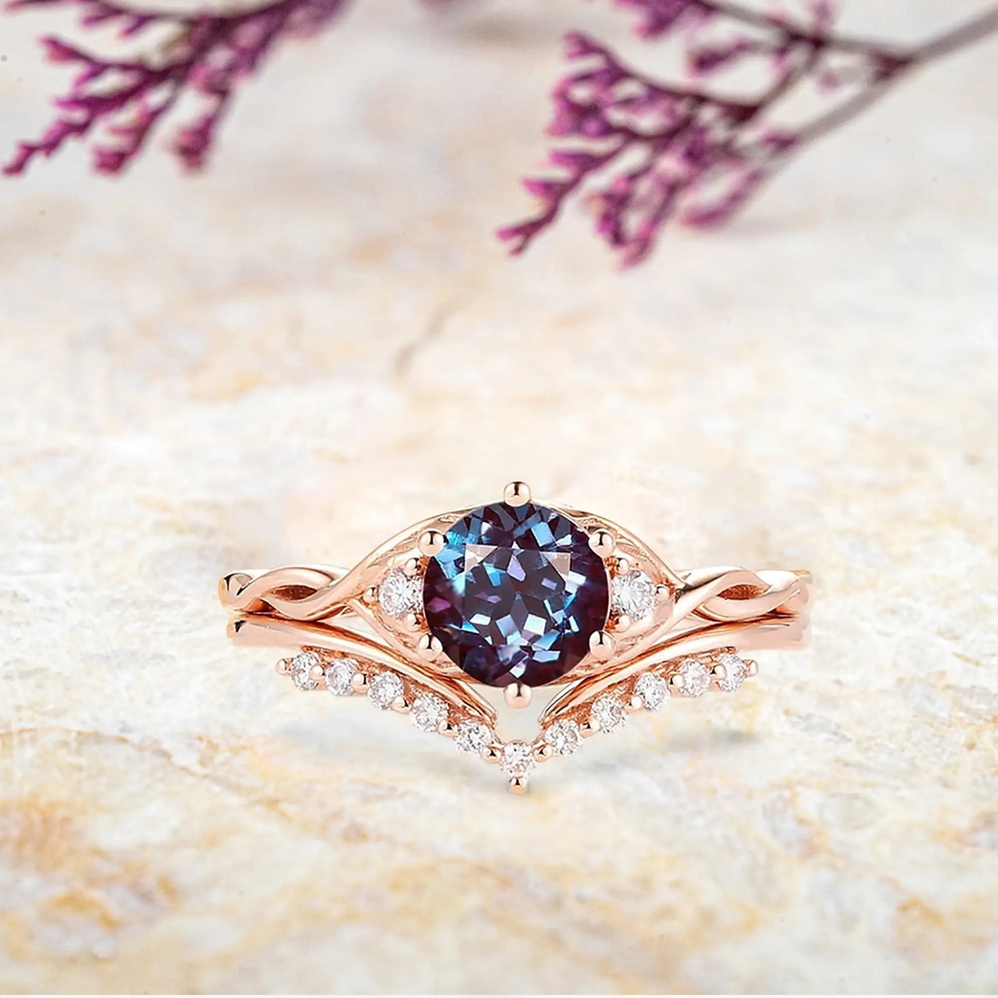Round alexandrite engagement ring with three stone setting and twisted rose gold band with chevron wedding band set