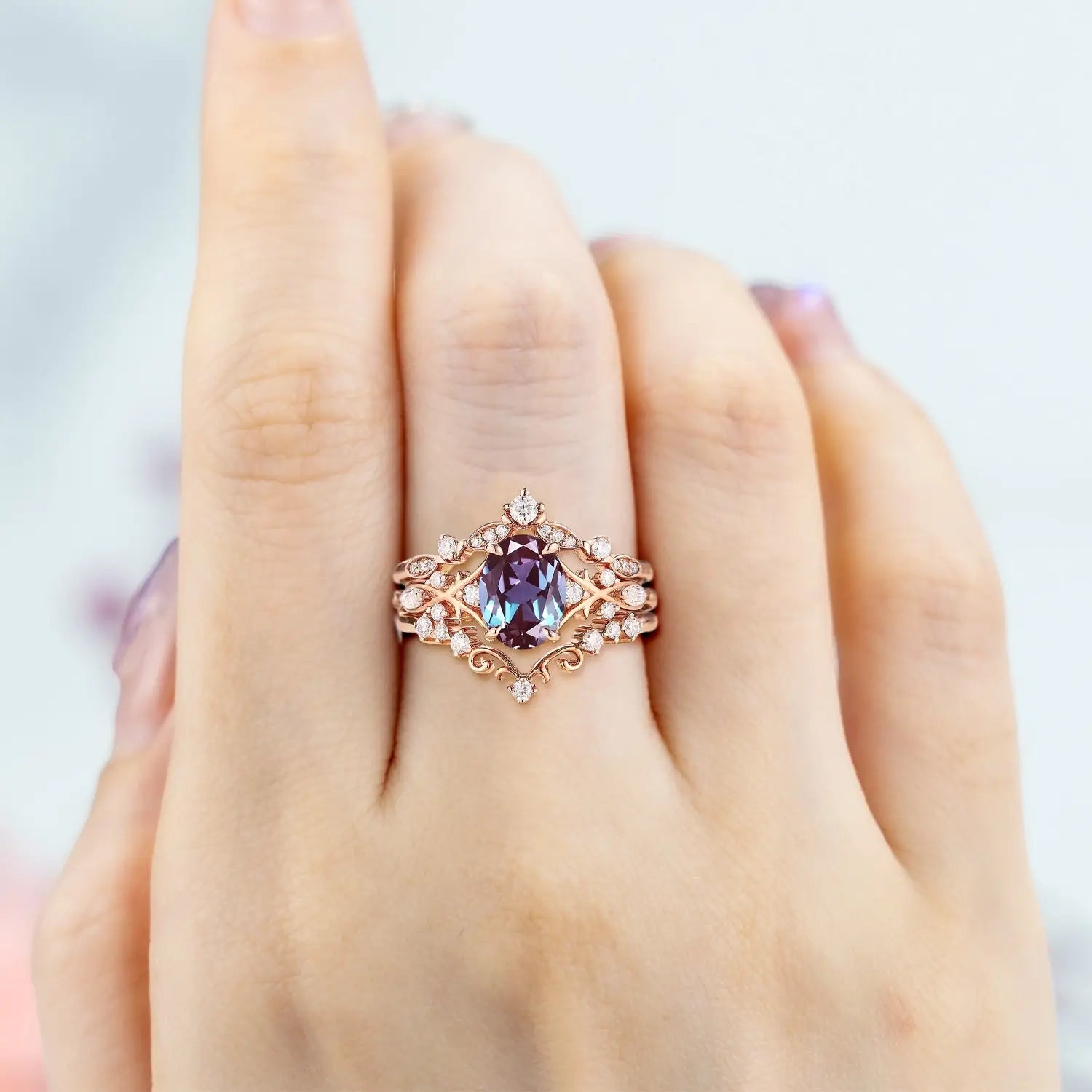 Woman wearing oval alexandrite engagement ring set in rose gold