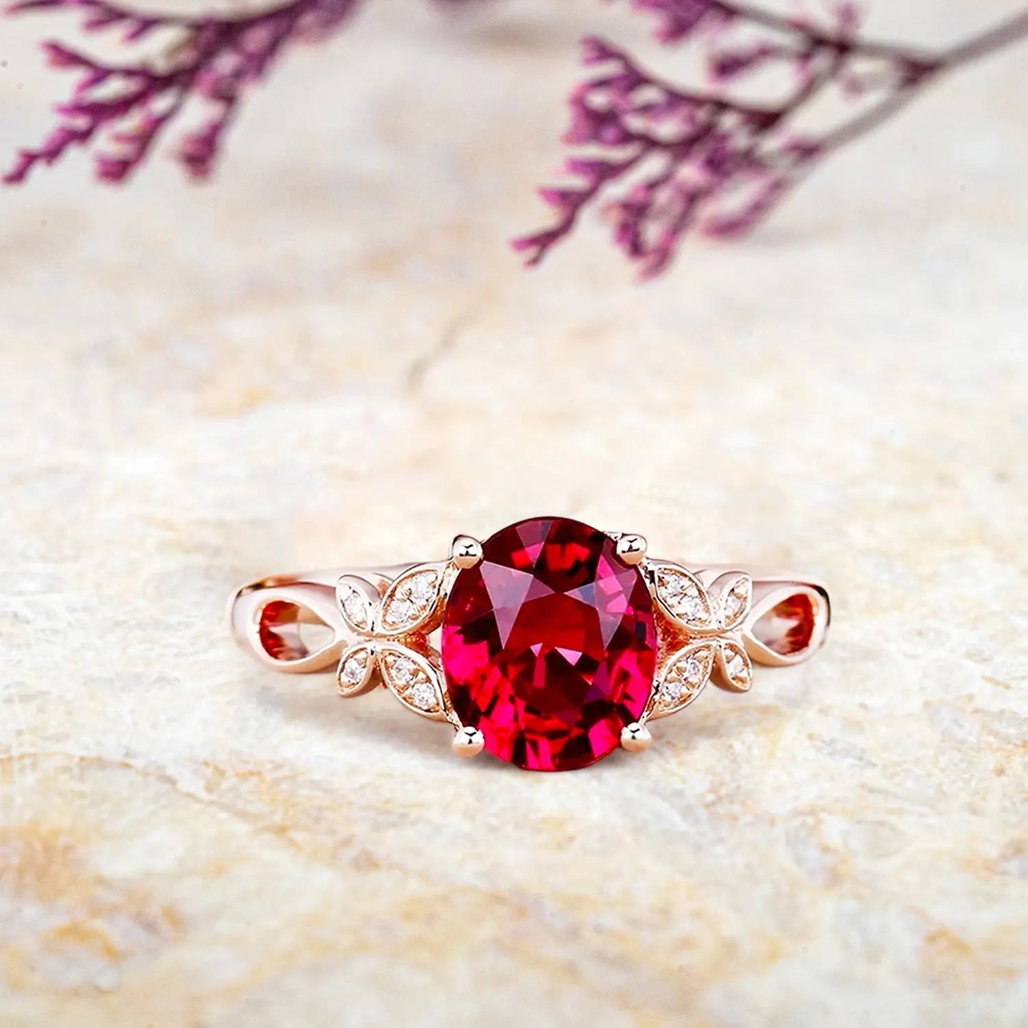 Oval ruby engagement ring with butterfly floral design and diamond accents on rose gold band