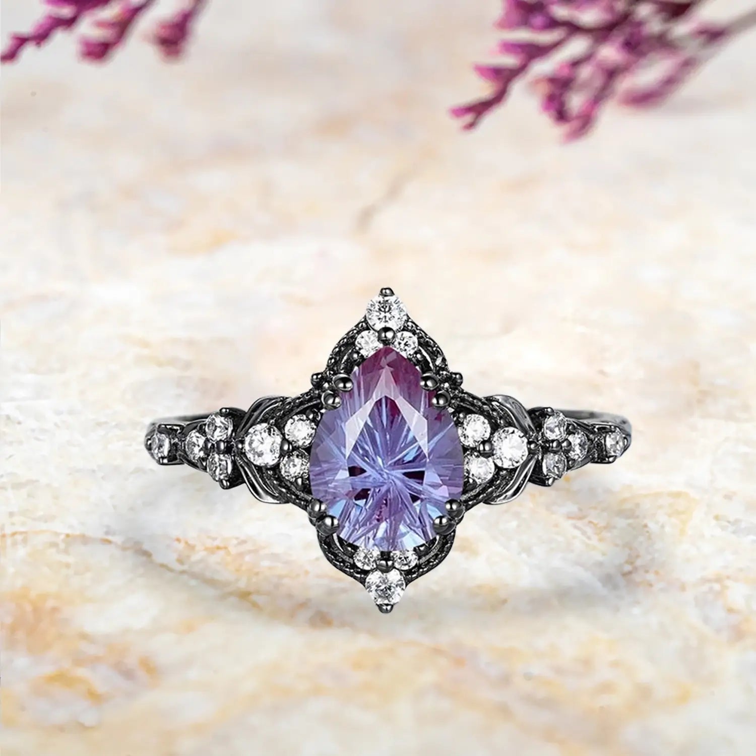 Pear alexandrite fireworks cut engagement ring with leaf inspired cluster halo and chevron wedding band in black gold