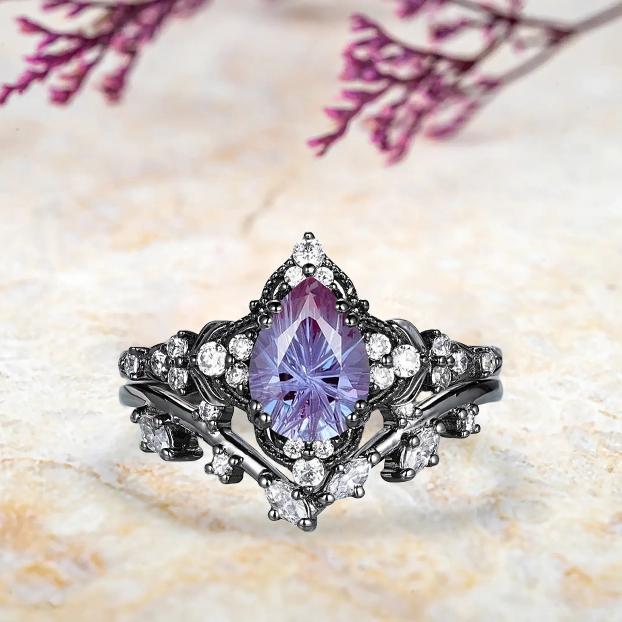 Pear alexandrite fireworks cut engagement ring with leaf inspired cluster halo and chevron wedding band set in black gold
