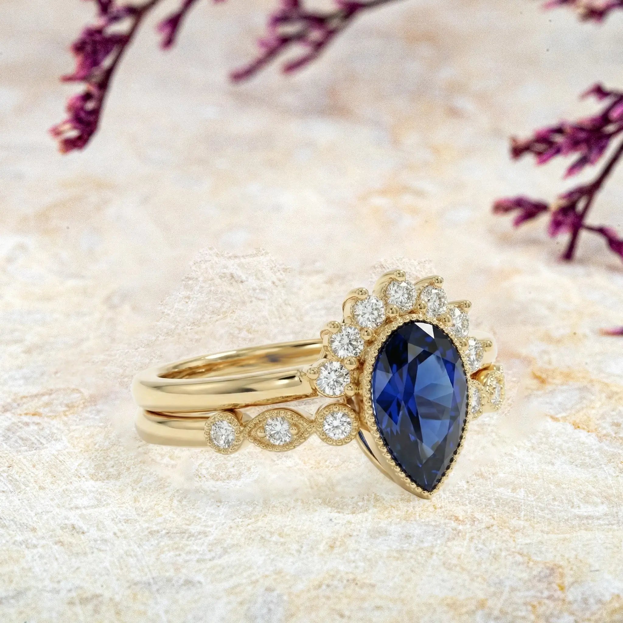 Side view of pear sapphire ring showing milgrain bezel and stacking band