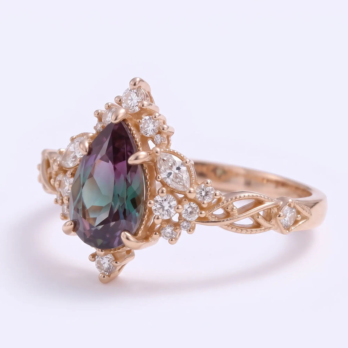Left angled view of Selviora pear-shaped lab alexandrite engagement ring showing the delicate milgrain setting, intertwined gold shoulders and vintage filigree details.