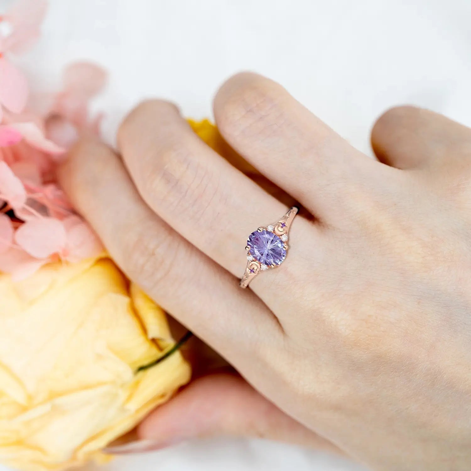 Woman wearing alexandrite moon engagement ring in rose gold