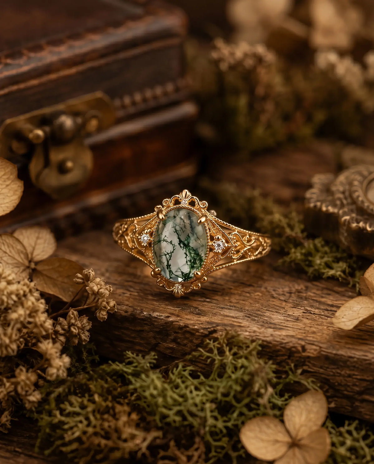 vintage Oval moss agate leaf ring photographed at an angle on dark stone with small dry twigs, showing natural green inclusions