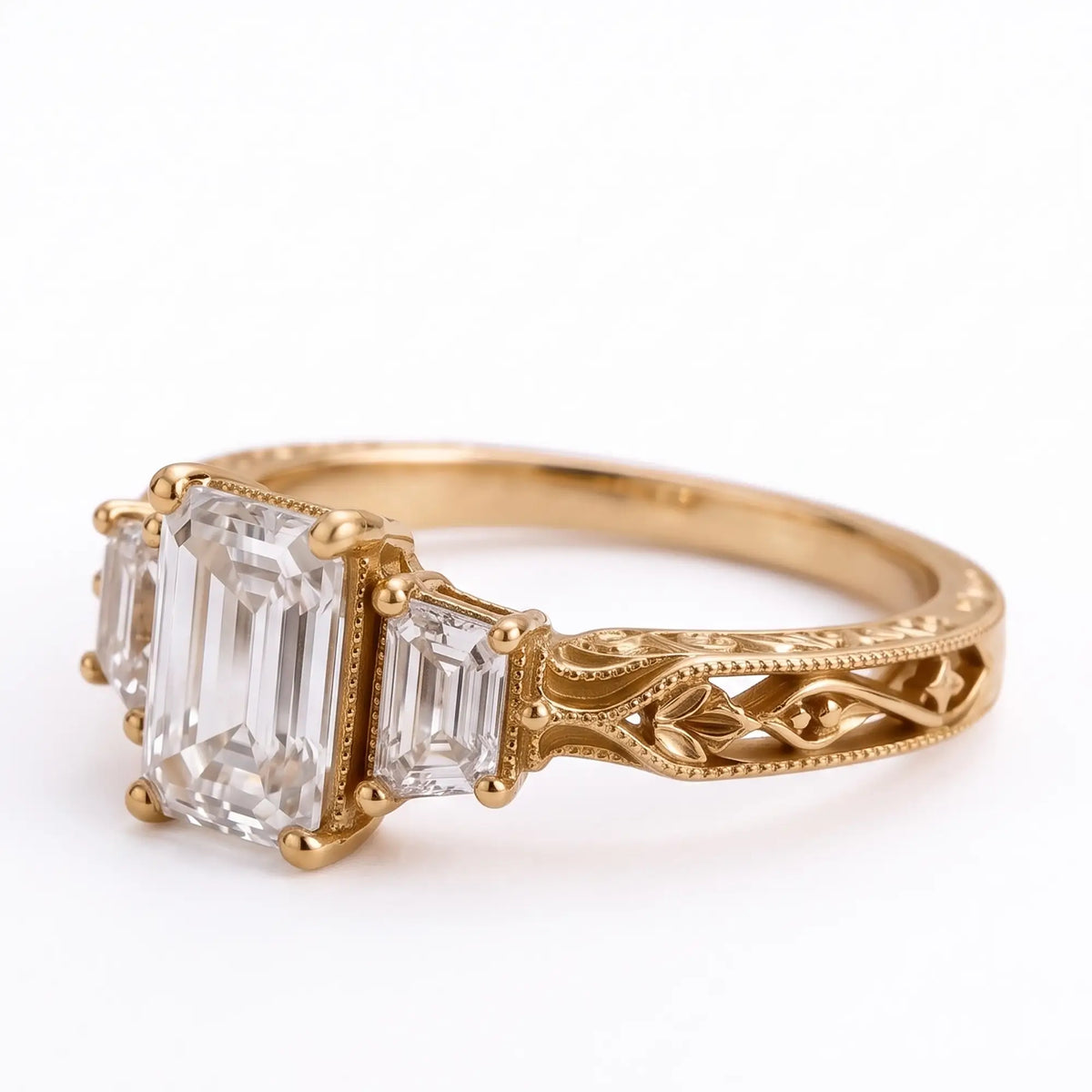 Three quarter view of emerald cut moissanite engagement ring with trapezoid accents and openwork leaf filigree