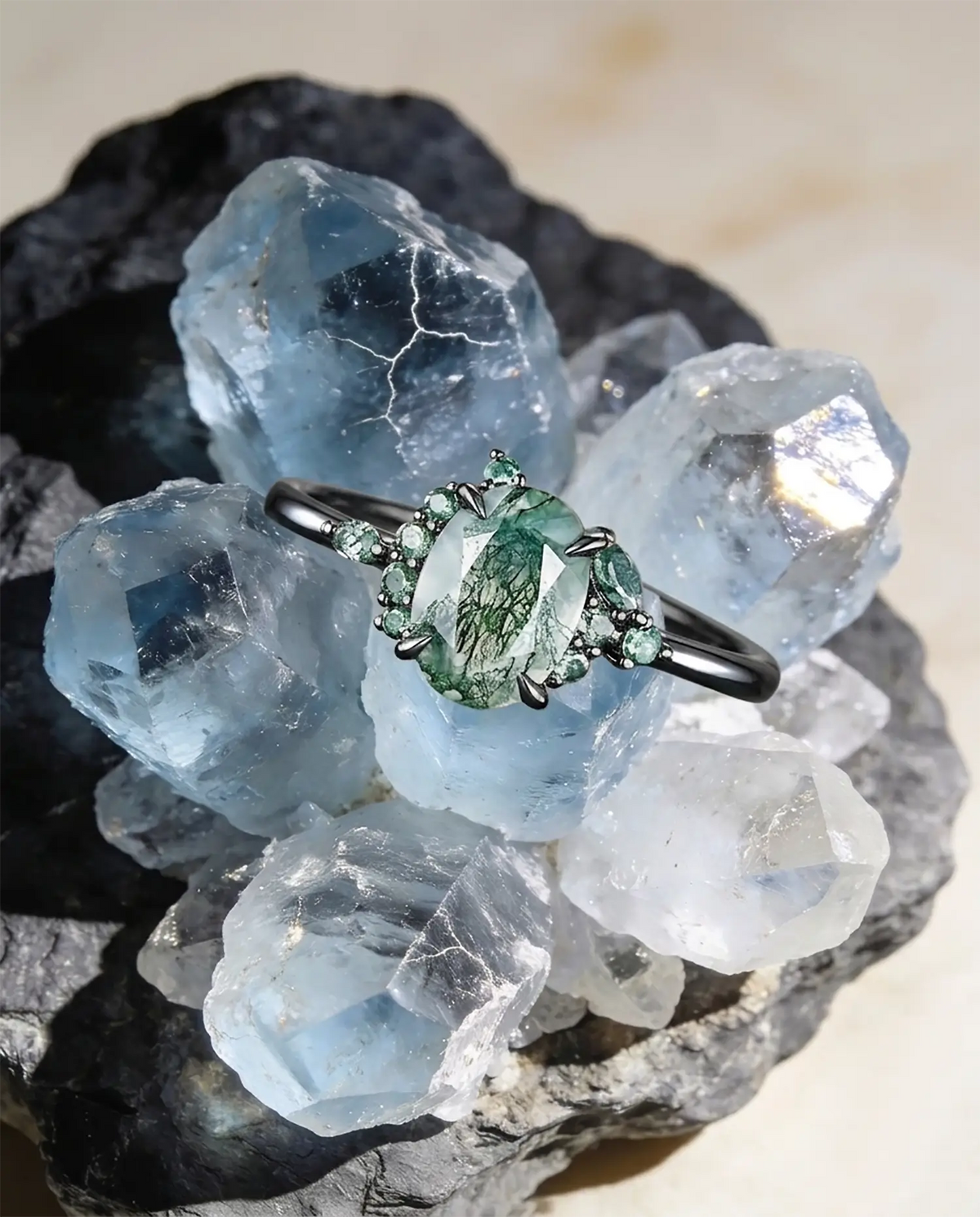 An 18k rose gold oval cut moss agate engagement ring pressed on the crystal
