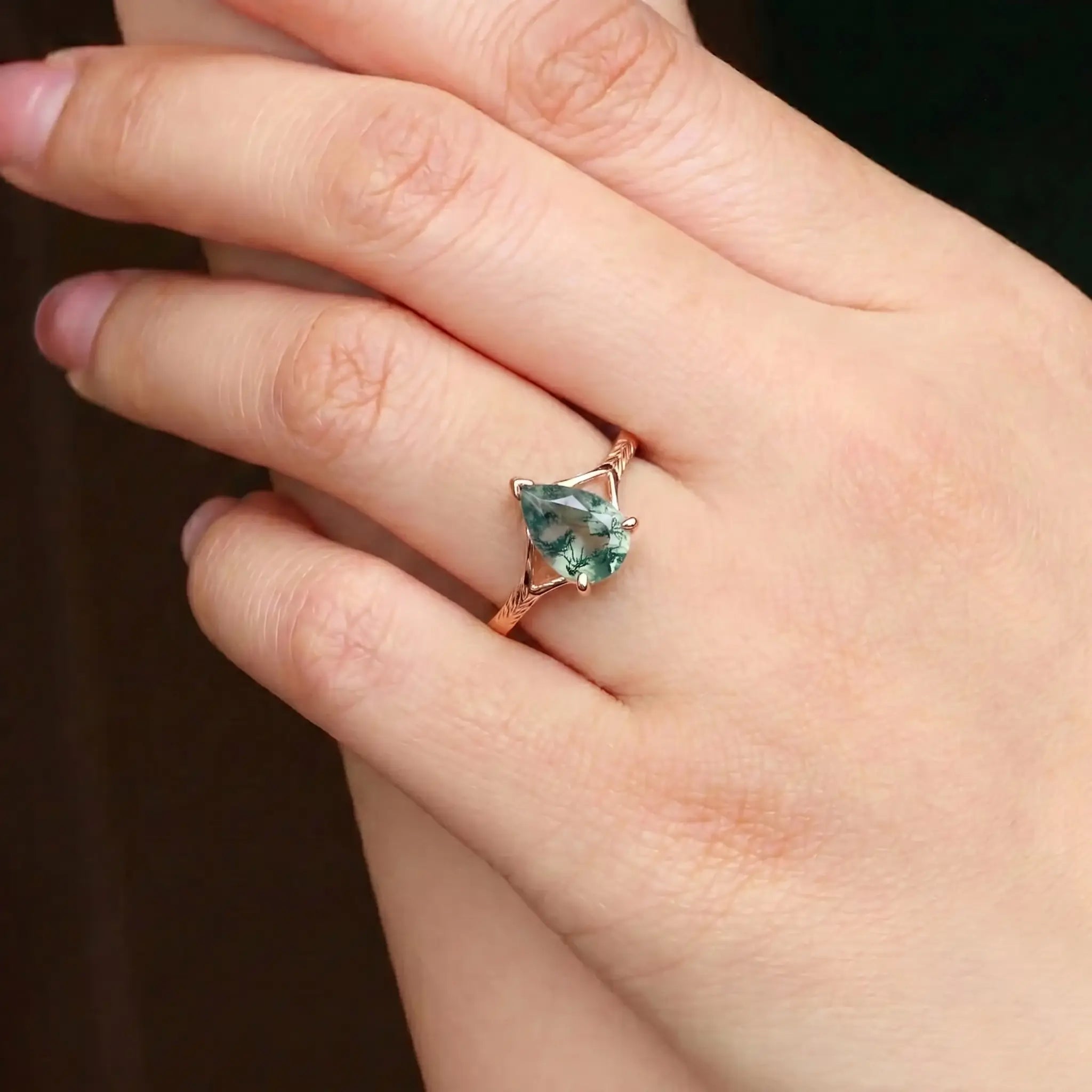 Woman wearing pear moss agate rose gold engagement ring minimalist leaf band