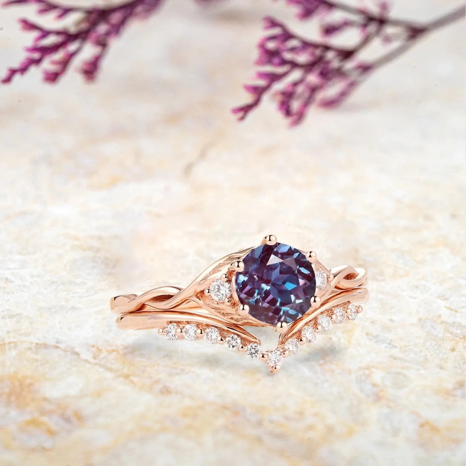 Woman wearing round alexandrite three stone engagement ring with twisted rose gold band and chevron wedding ring