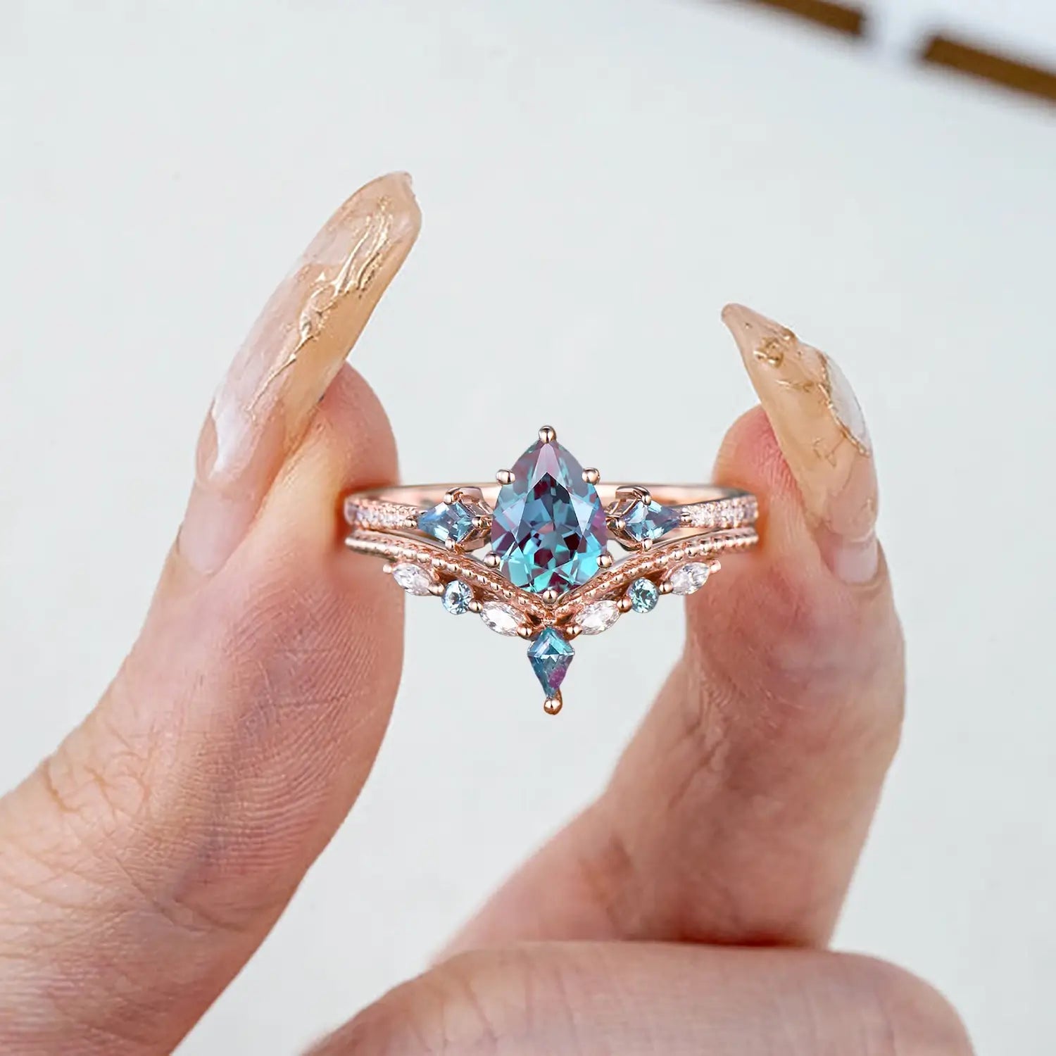 Woman wearing pear alexandrite engagement ring set rose gold vintage design