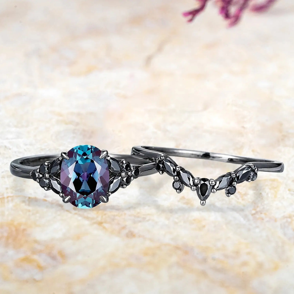 Oval alexandrite cluster engagement ring and black onyx chevron wedding band displayed separately showing Gothic June birthstone bridal set