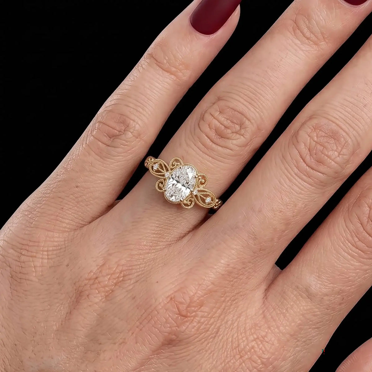 Aurevielle Edwardian-inspired oval moissanite engagement ring worn on a finger, displaying its delicate openwork filigree band.
