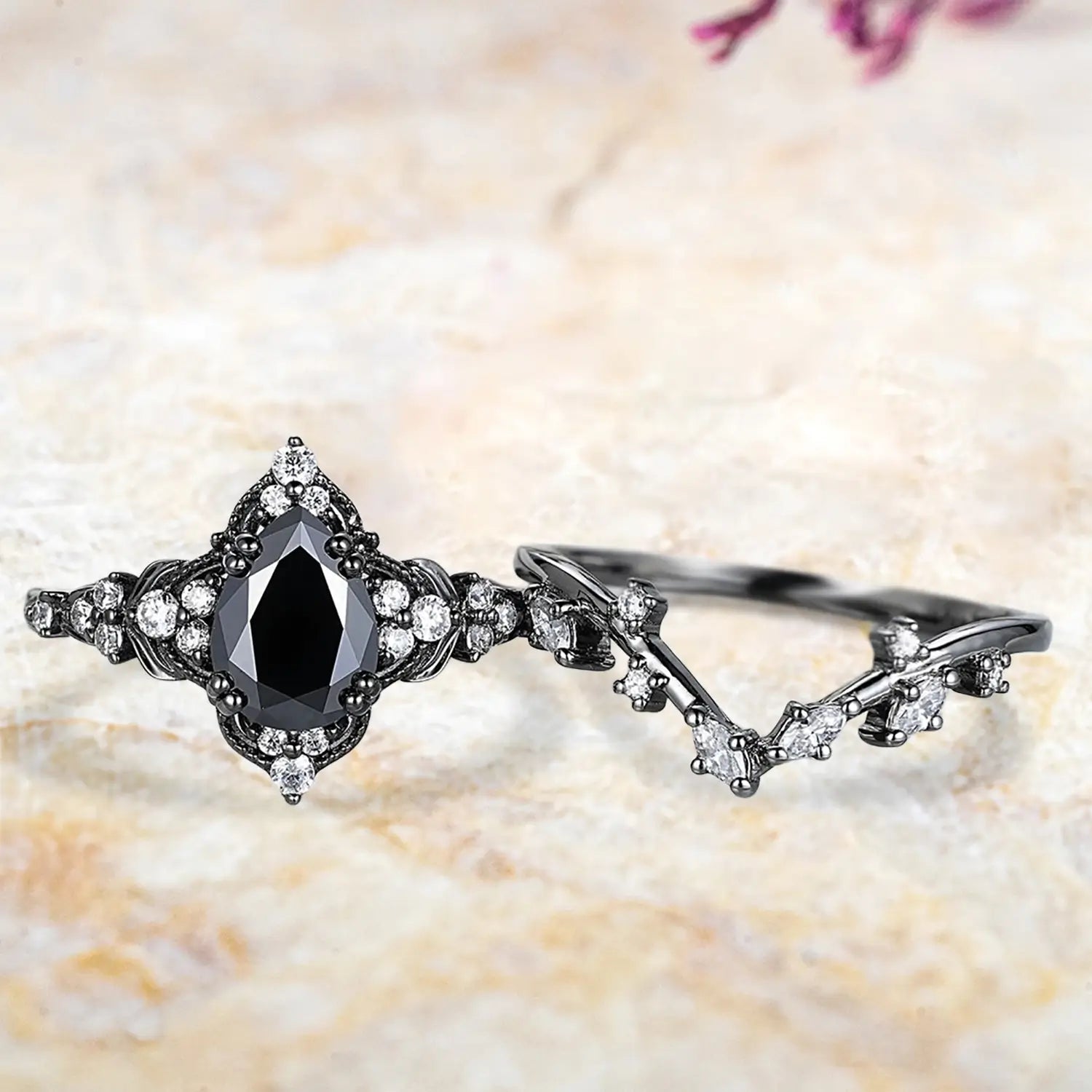 Pear black onyx leaf crown engagement ring and curved chevron wedding band displayed separately showing luxury vintage bridal set