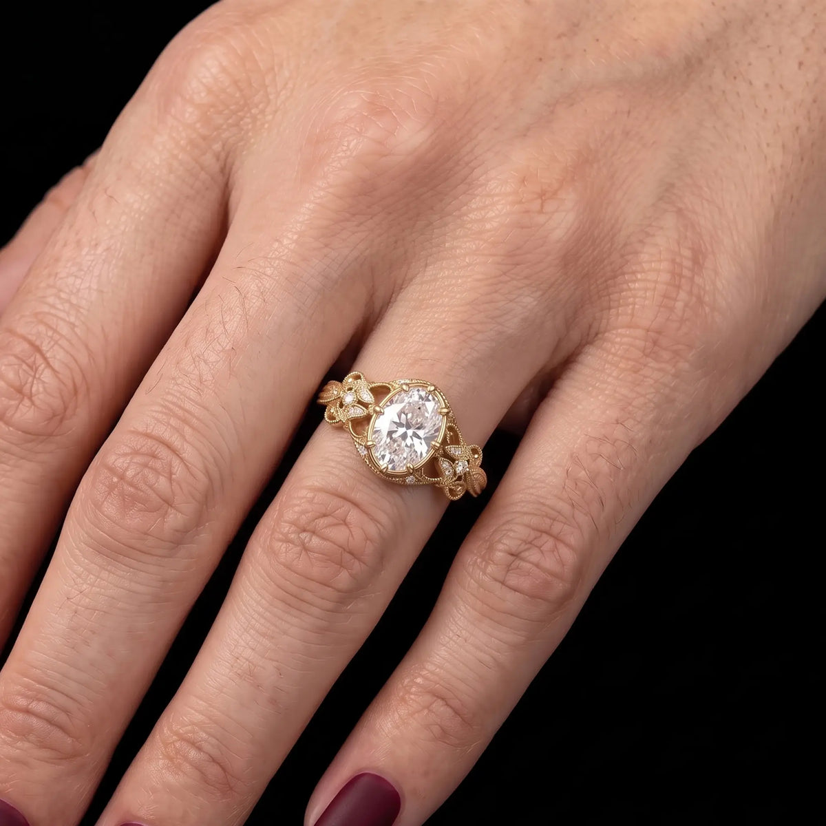 Calerienne oval moissanite engagement ring worn on hand, showing the elongated center stone and ornate filigree shoulders