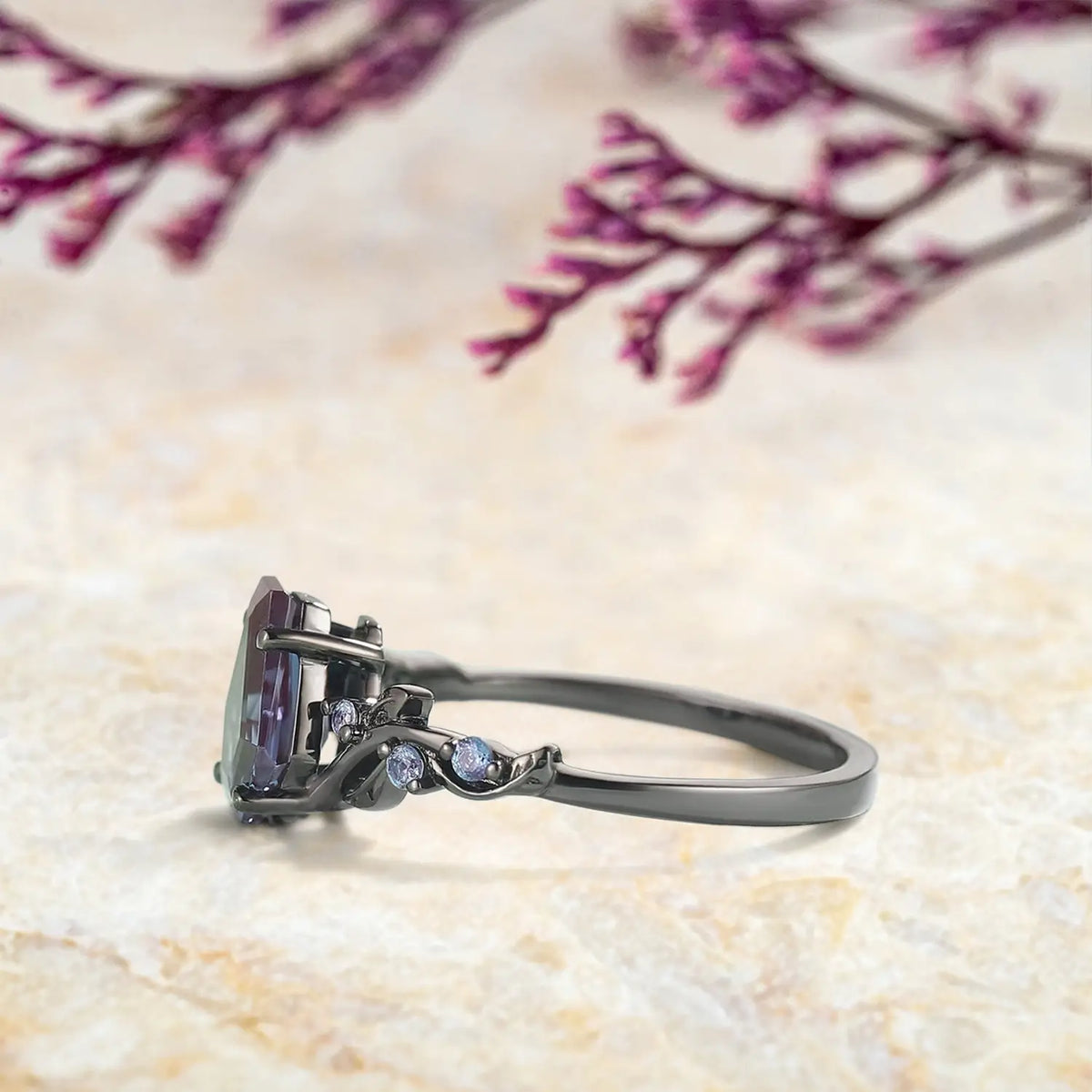 Close up detail of coffin cut alexandrite center stone with round alexandrite accents in leaf setting