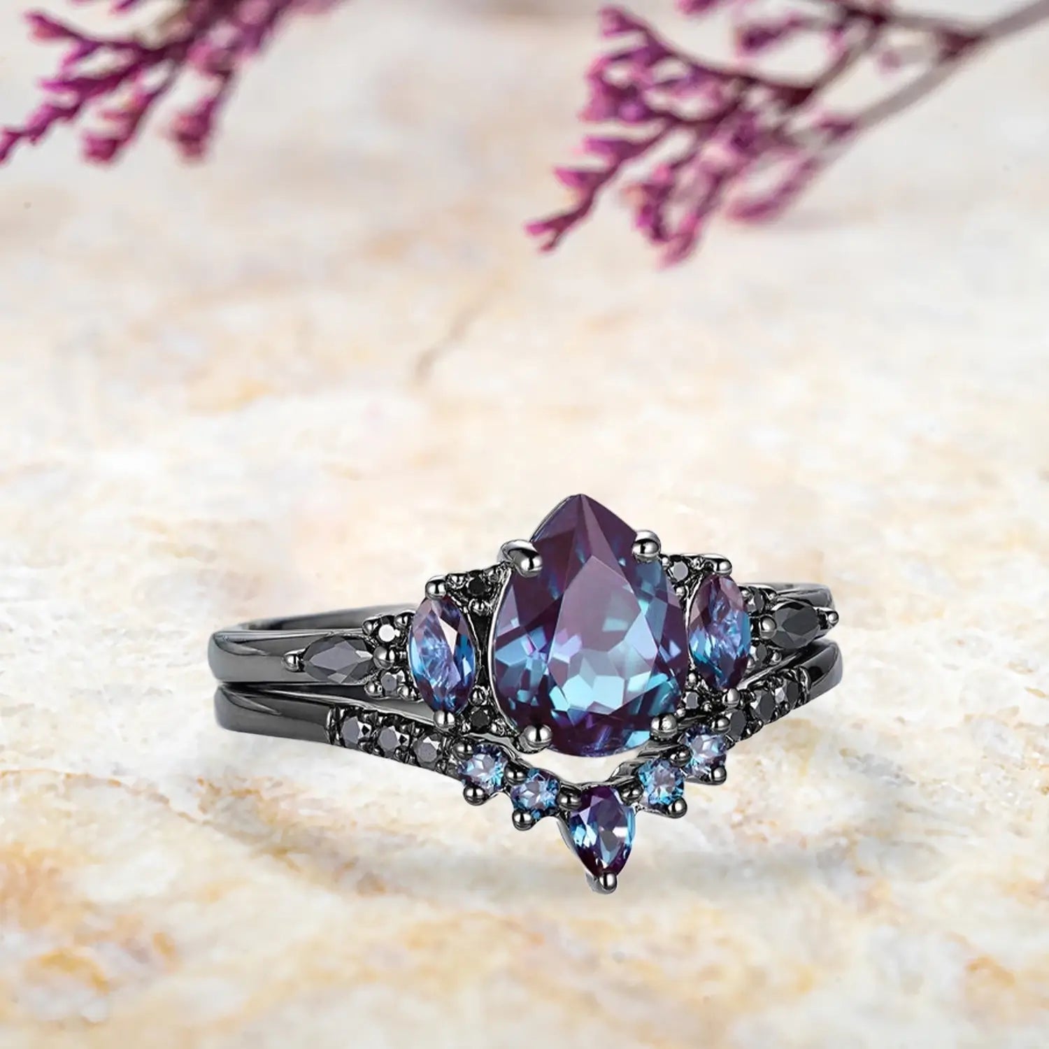 Side view of pear alexandrite ring showing black moissanite cluster design and curved chevron wedding band profile