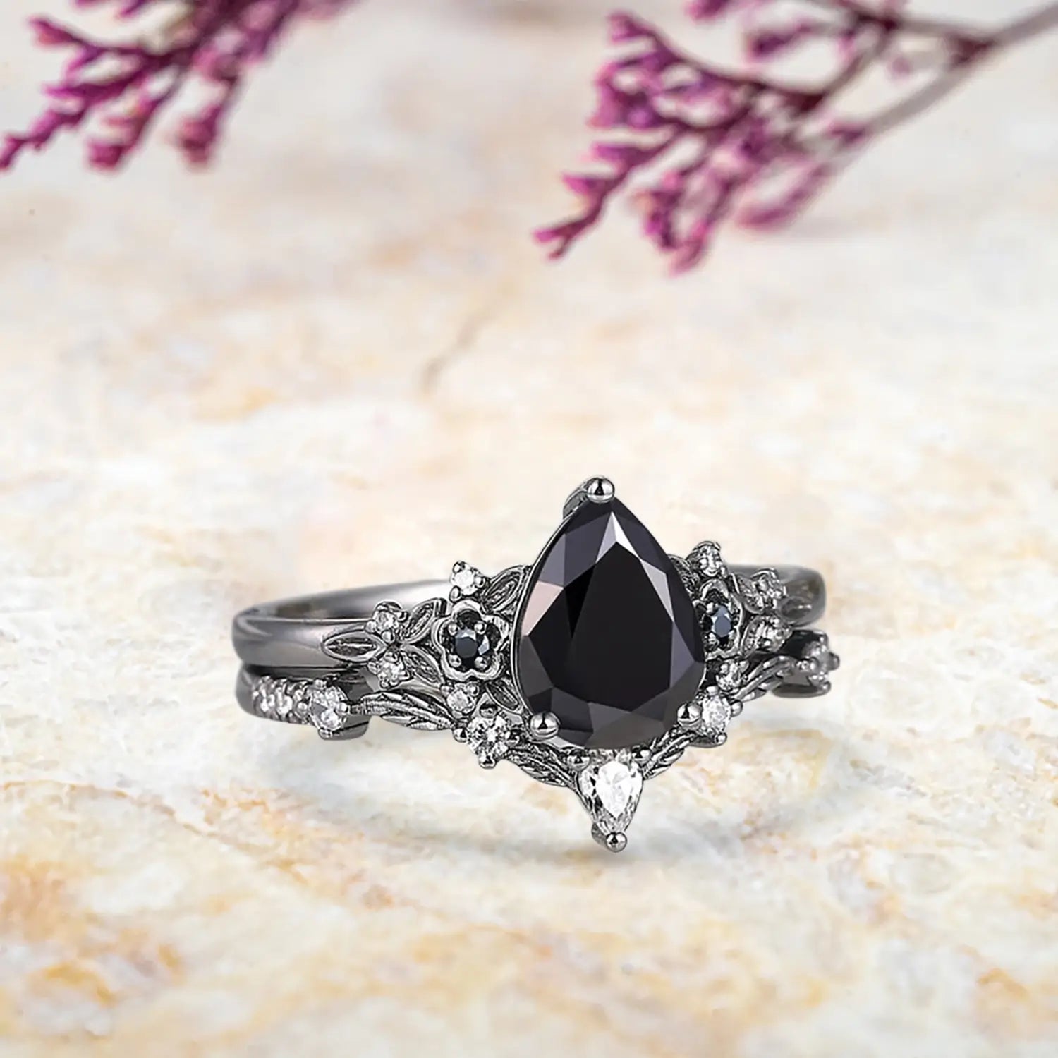 Side view of pear black onyx ring showing nature inspired floral cluster and curved leaf wedding band profile