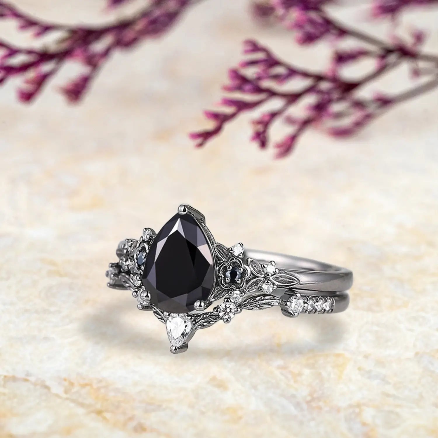 Side view of pear black onyx ring showing nature inspired floral cluster and curved leaf wedding band profile